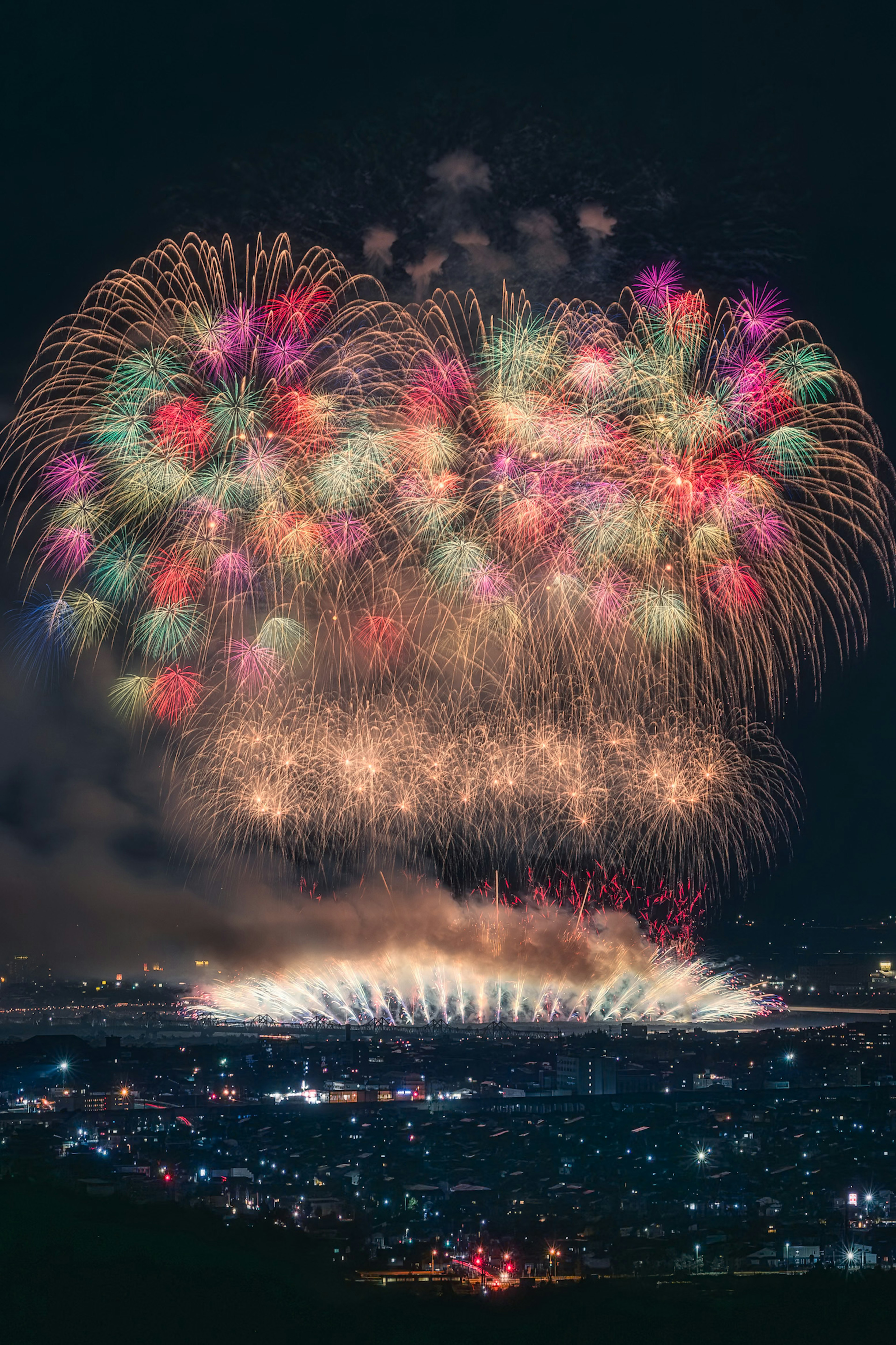 Colorful fireworks bursting in the night sky over a city landscape