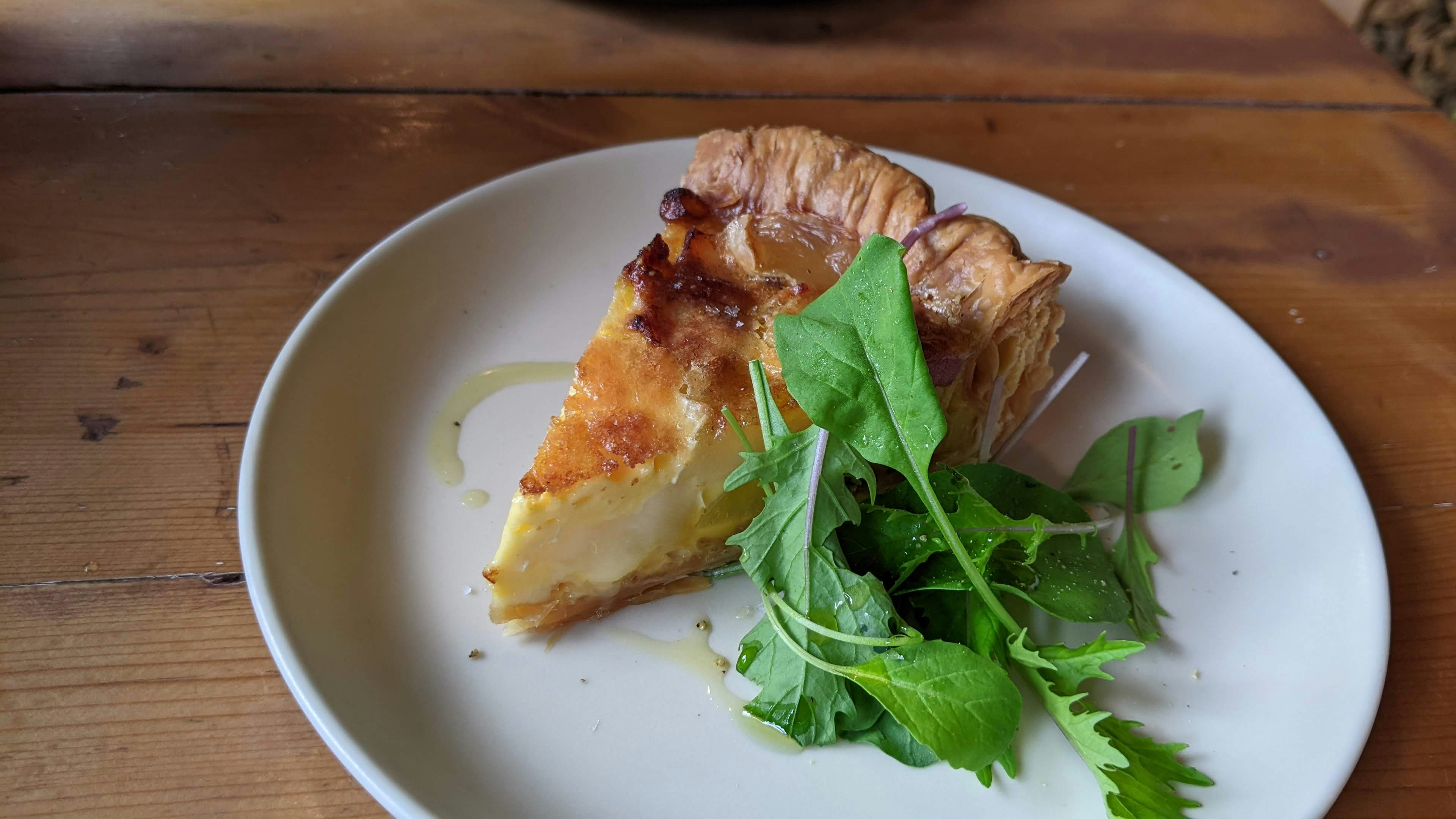 Irisan quiche disajikan dengan salad segar