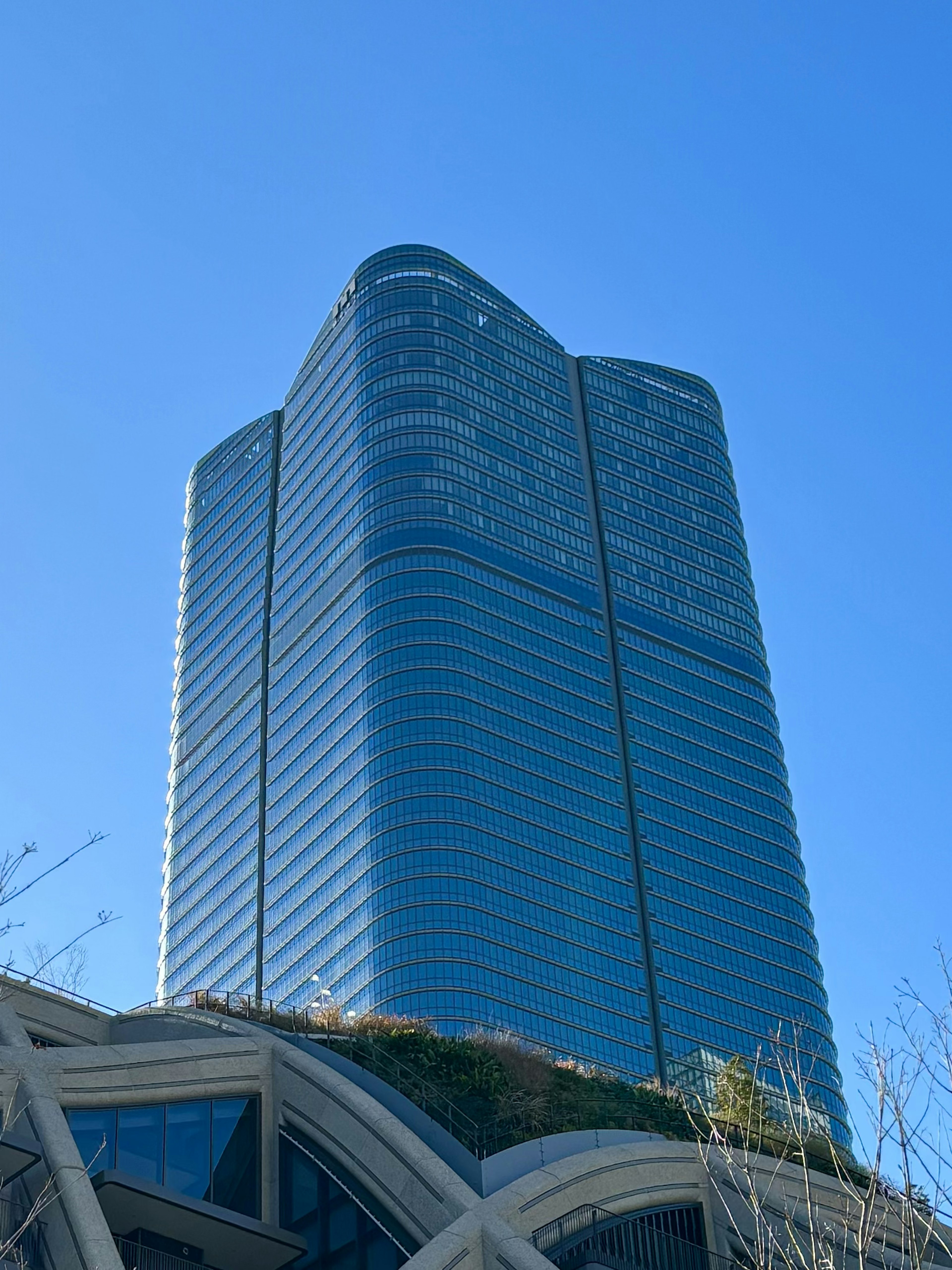 青空の下にそびえる近代的な高層ビルの鋭い輪郭