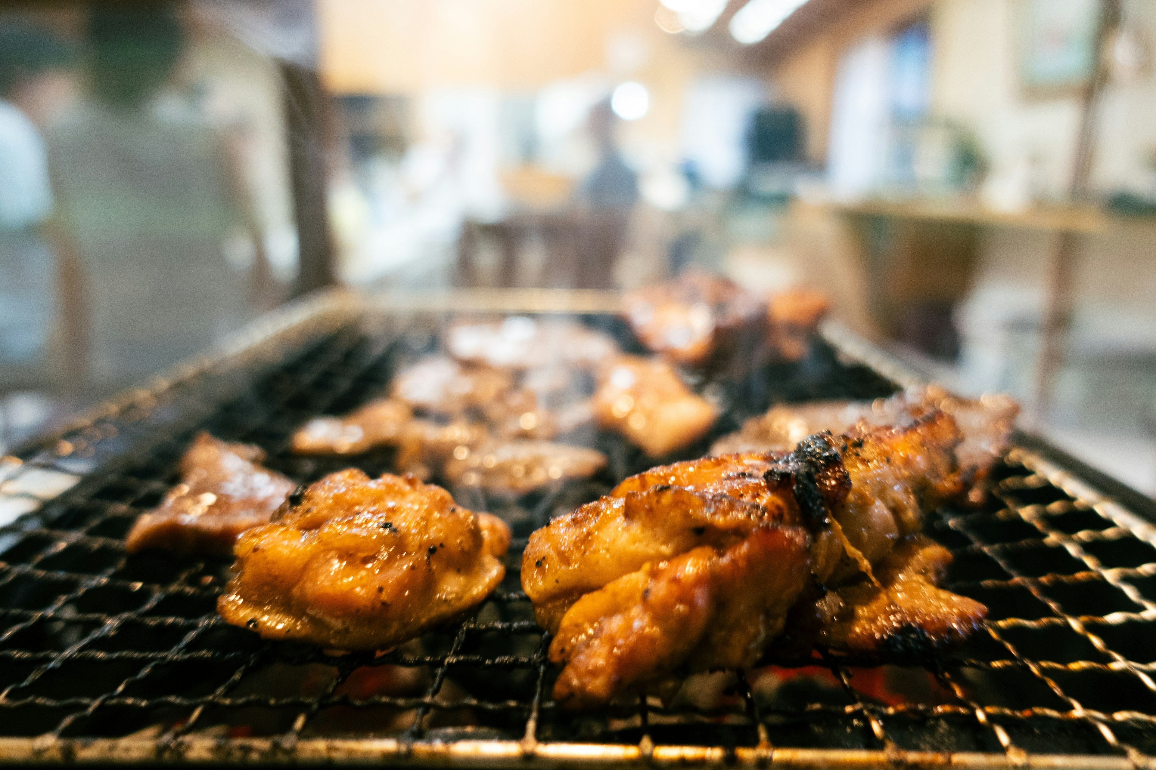 Grilled chicken pieces cooking on a barbecue grill