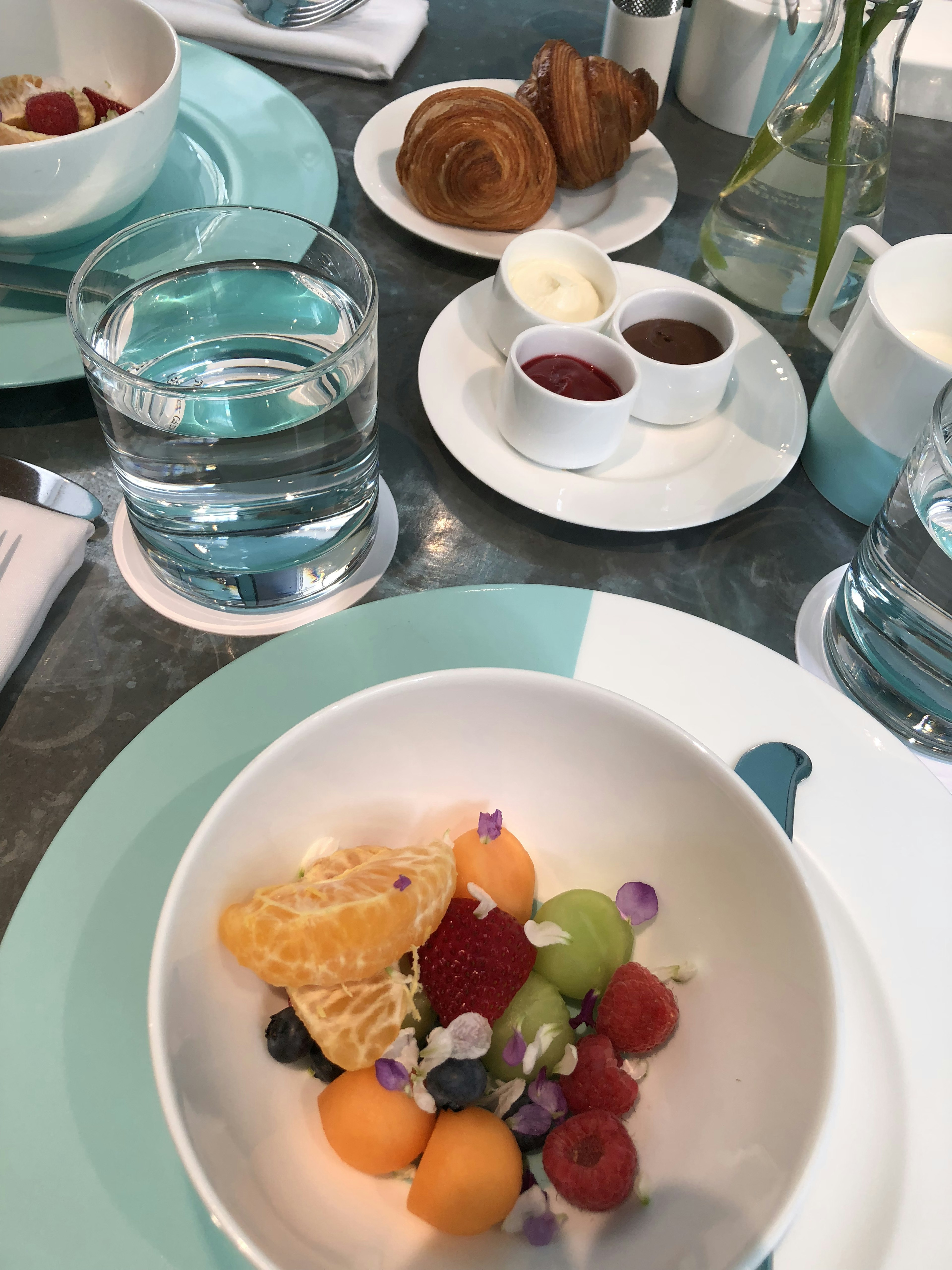 Insalata di frutta colorata e pasticcini su un tavolo per la colazione