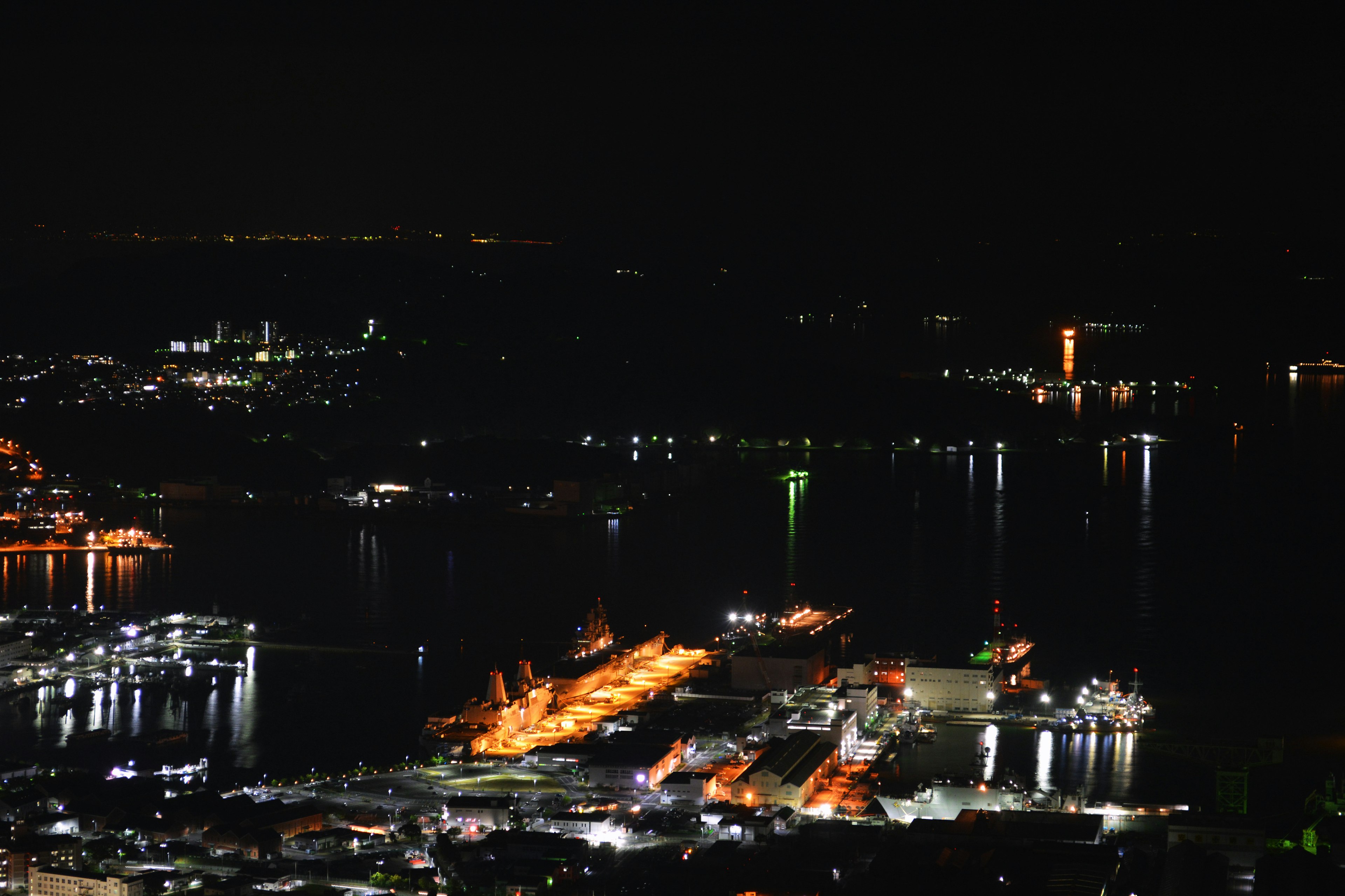 Vista notturna di un porto con navi e riflessi di luci