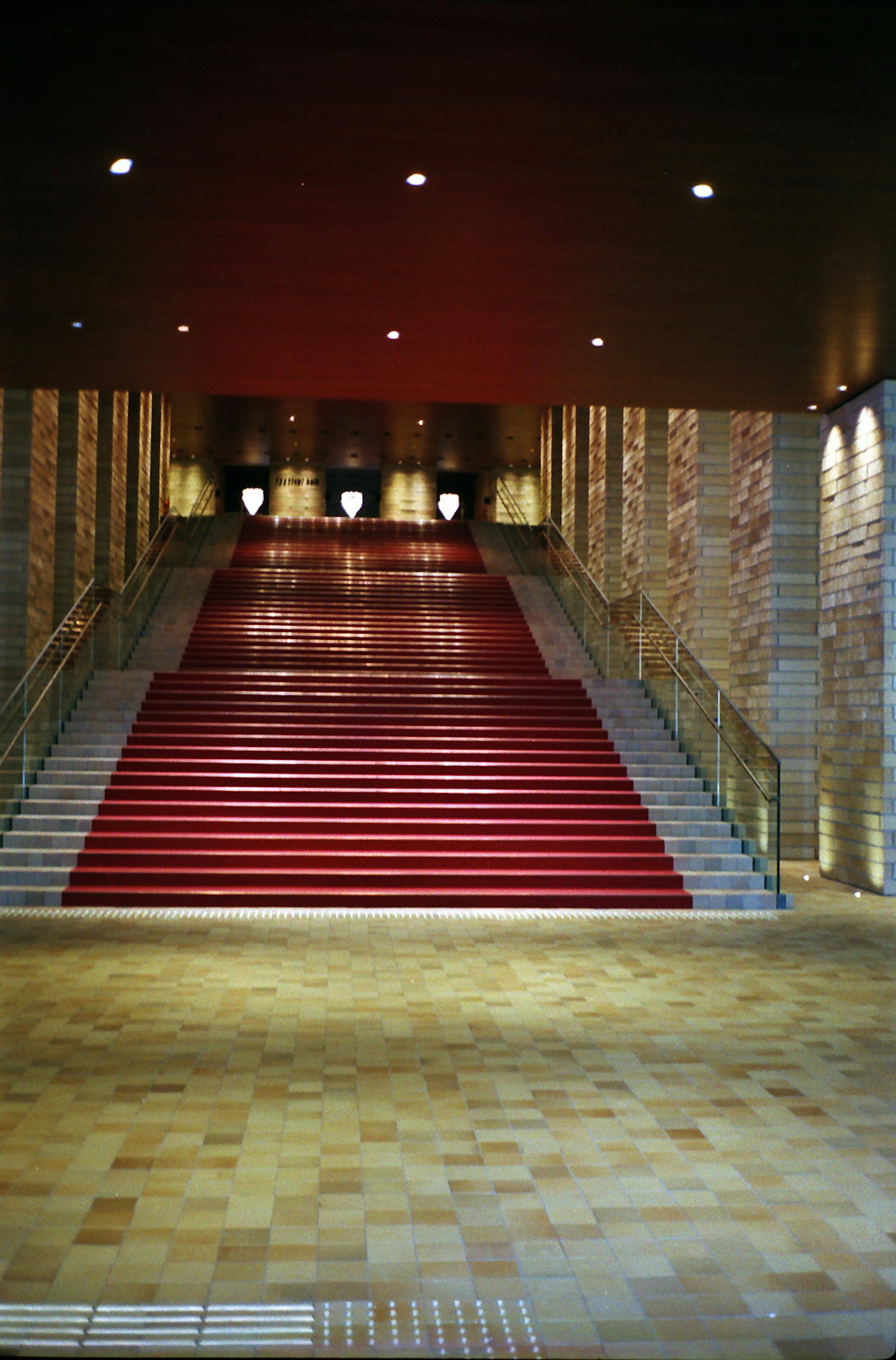 Entrada moderna con escaleras rojas y iluminación brillante