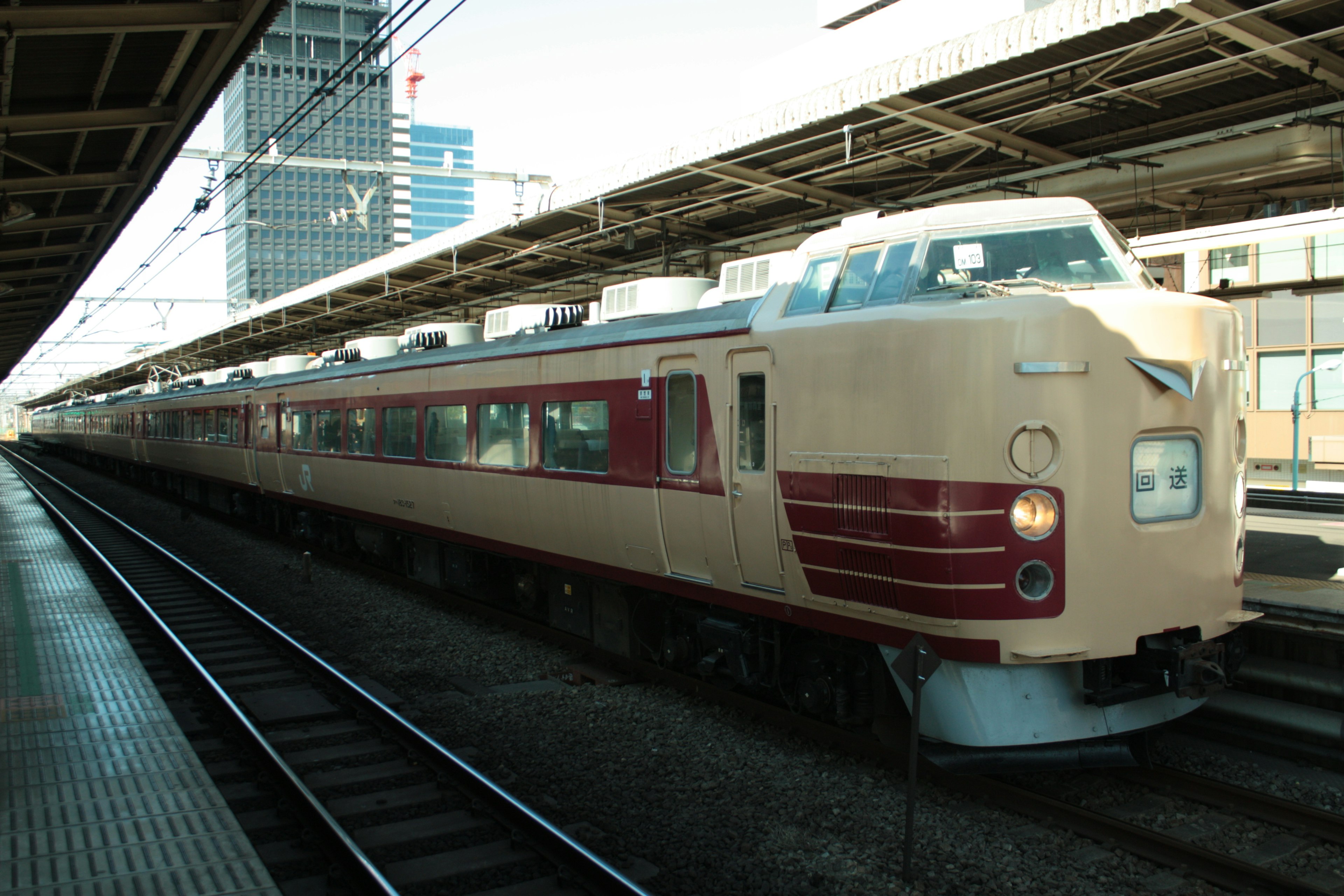 Treno espresso di colore marrone e crema in stazione