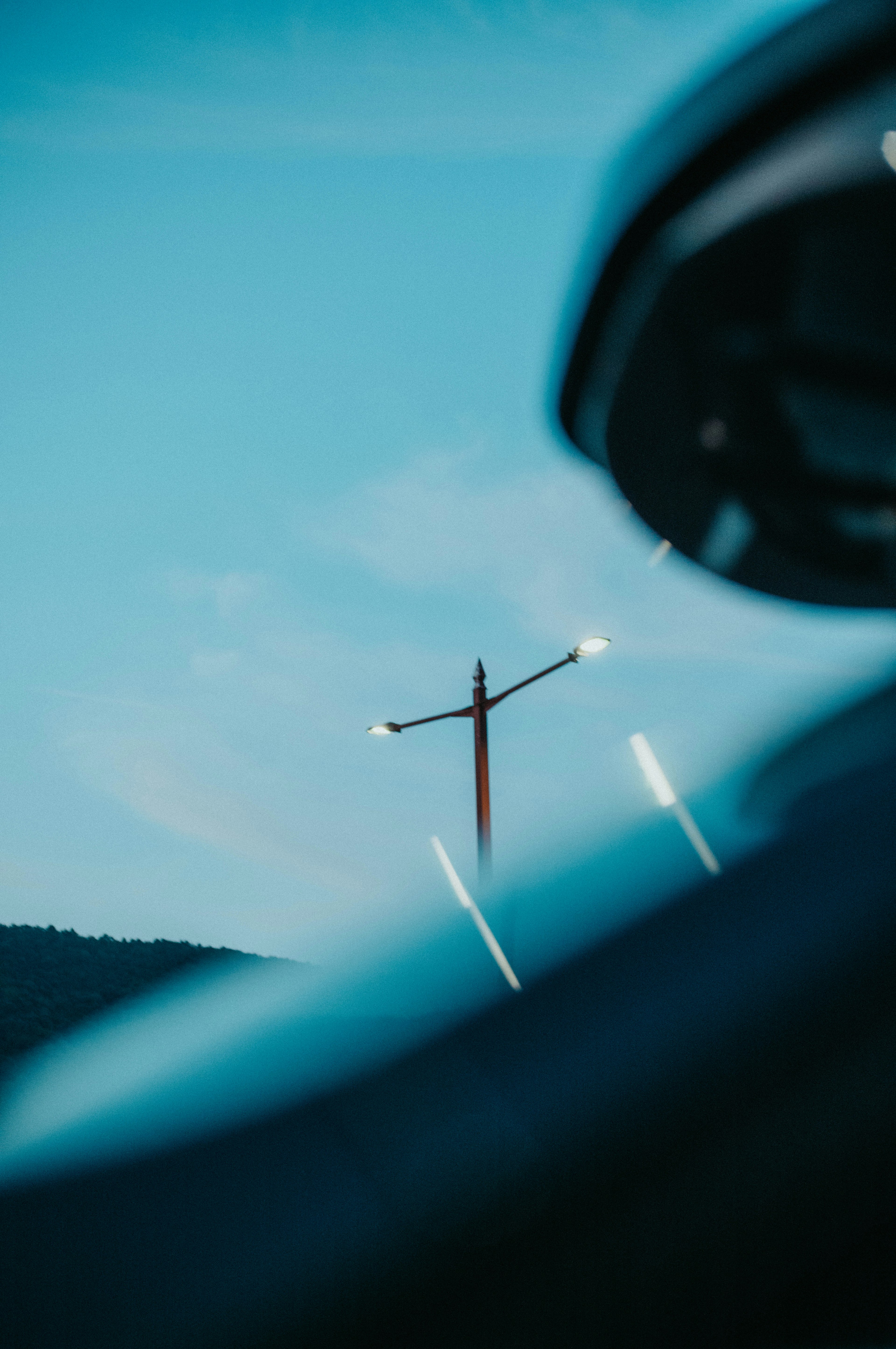 Lampadaire sur fond de ciel bleu avec un rétroviseur de voiture