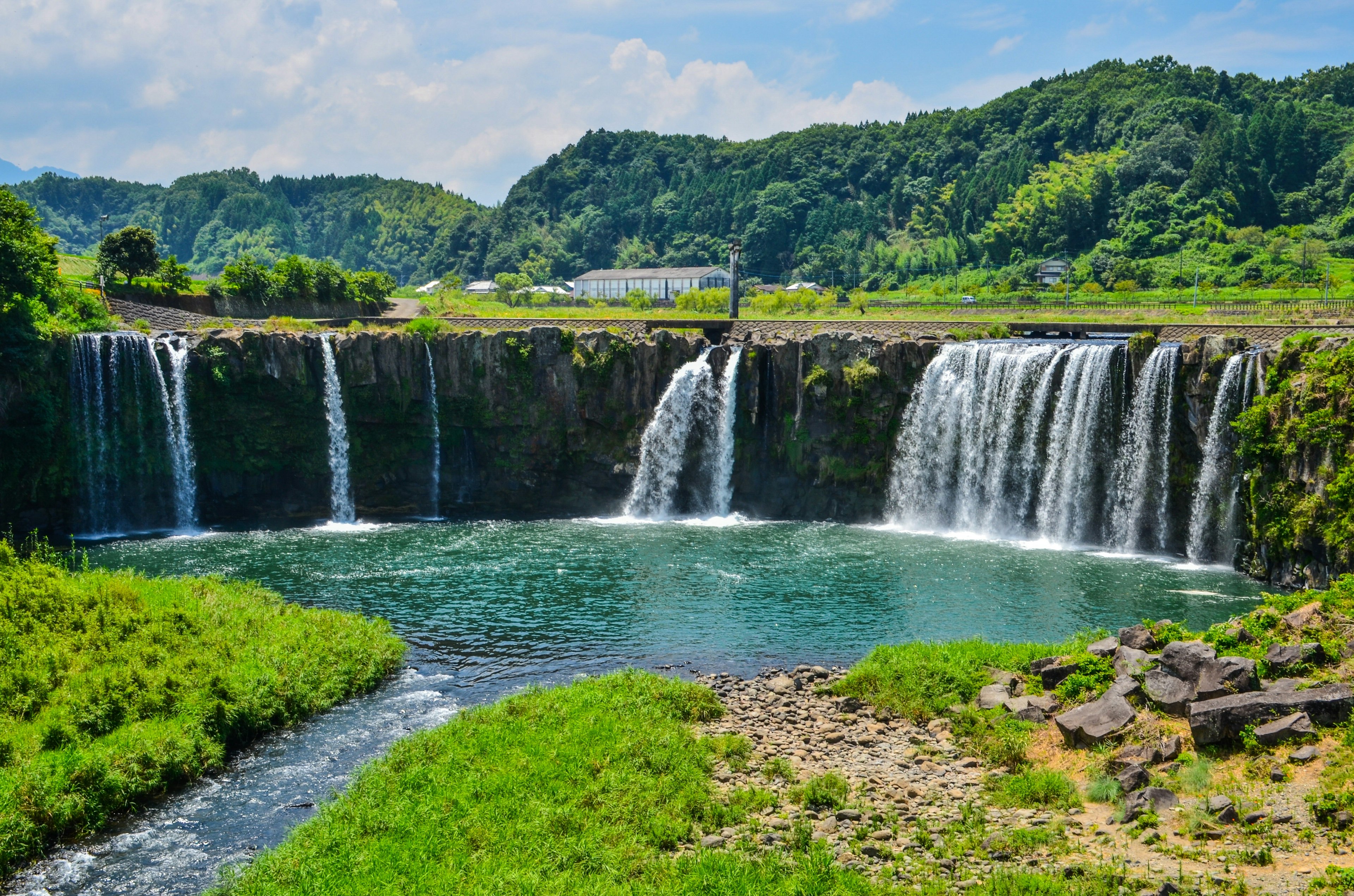 美しい滝と青い水の池が広がる自然の風景