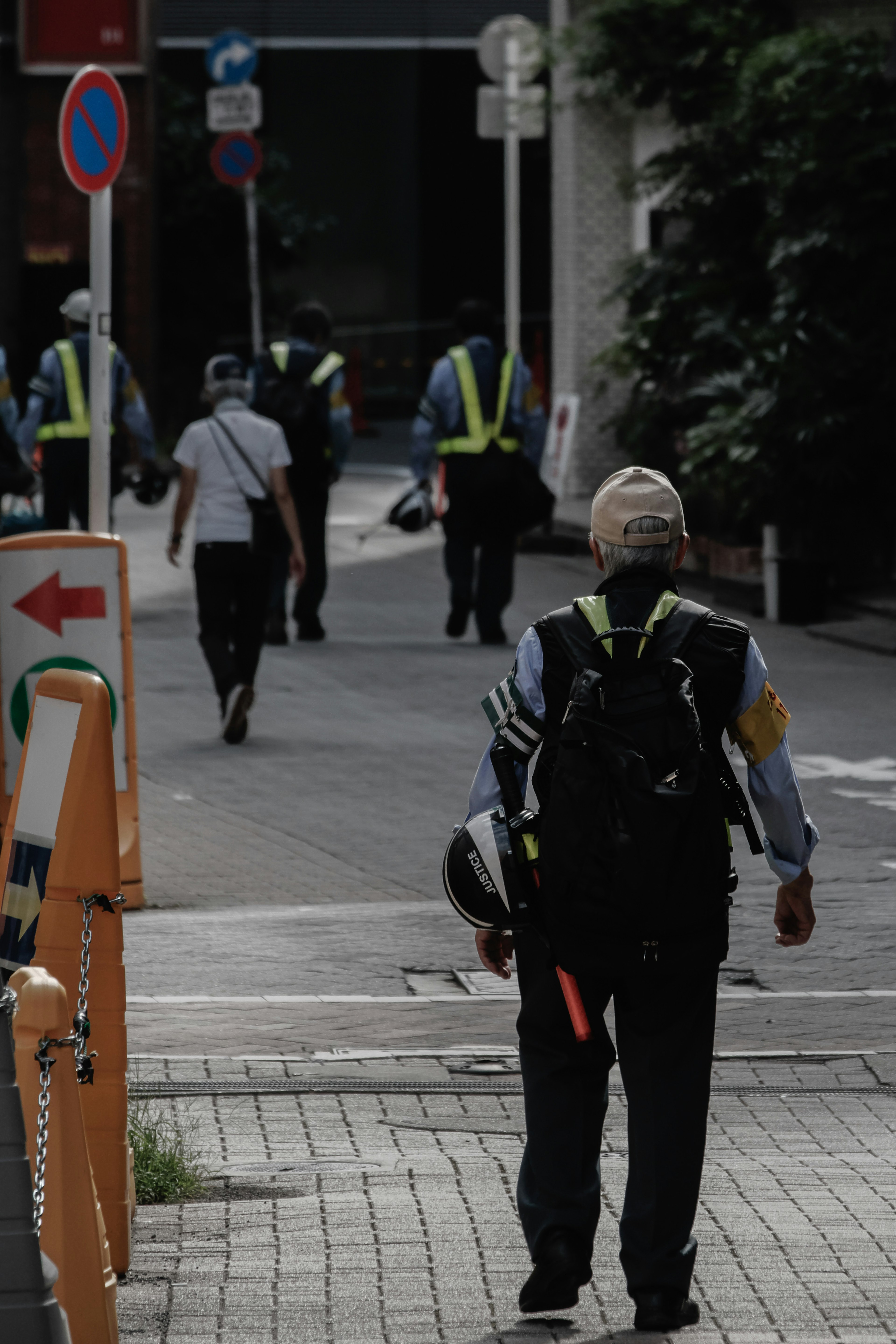 Personale di sicurezza che cammina per strada con uniformi e attrezzature visibili