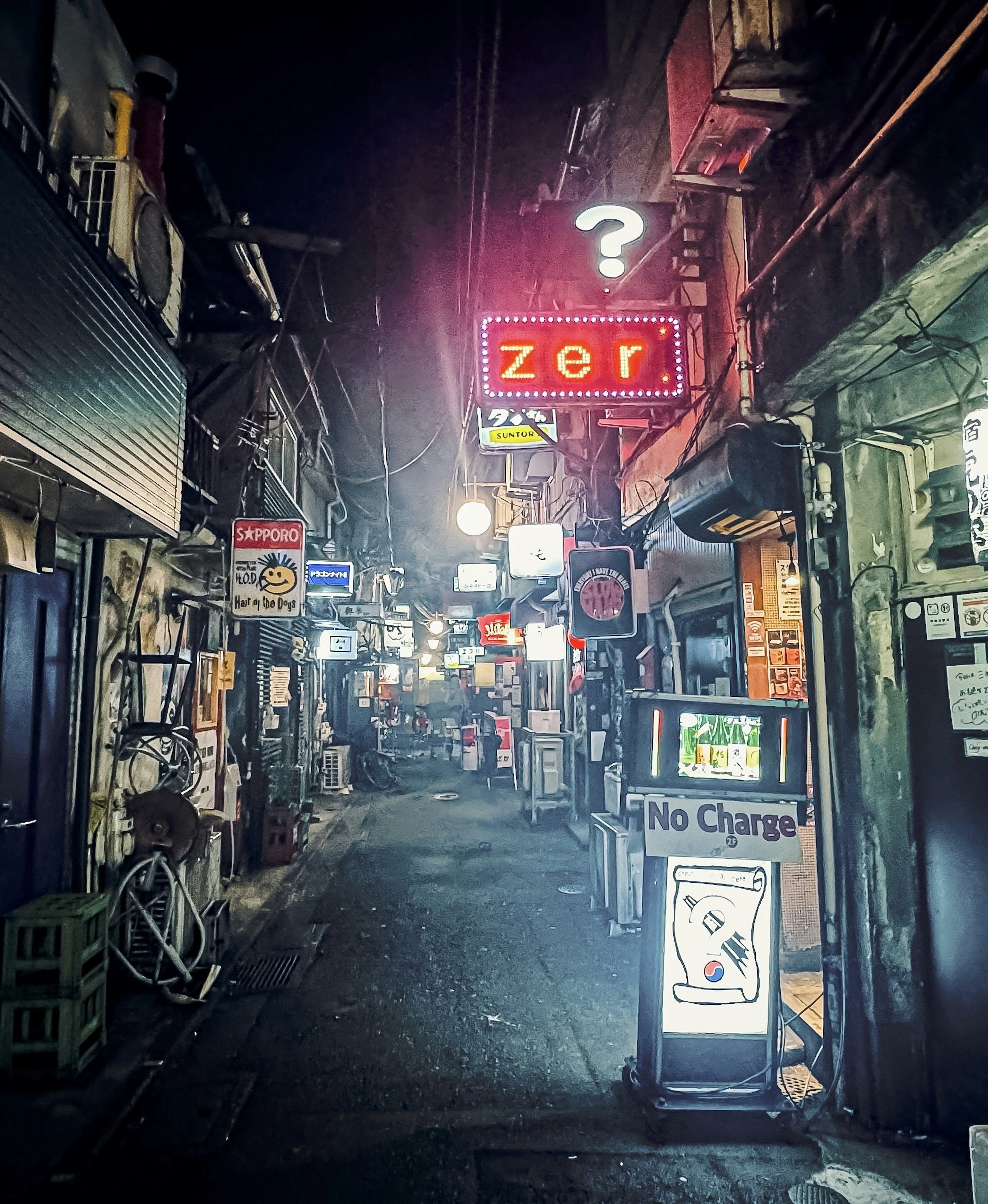 Callejón estrecho de noche con letreros de neón y ambiente tranquilo