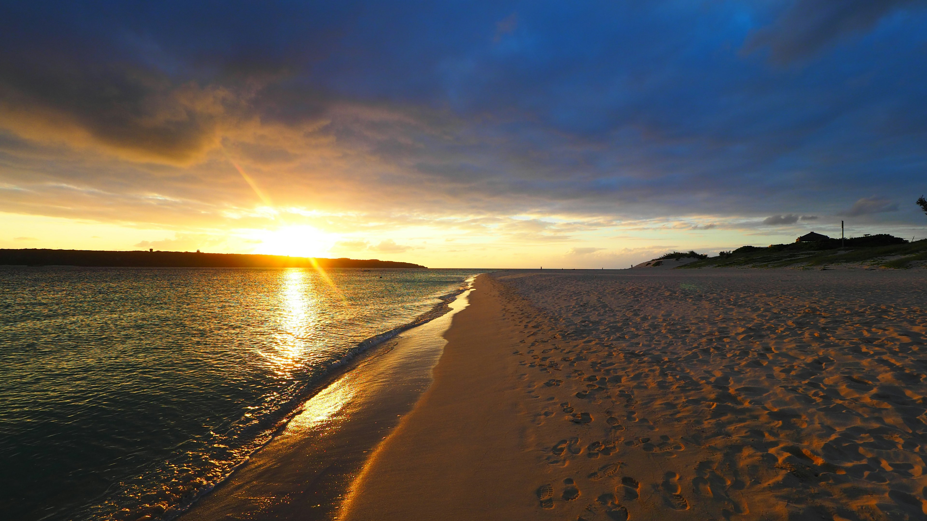 Bellissimo tramonto sulla spiaggia con mare calmo e sabbia