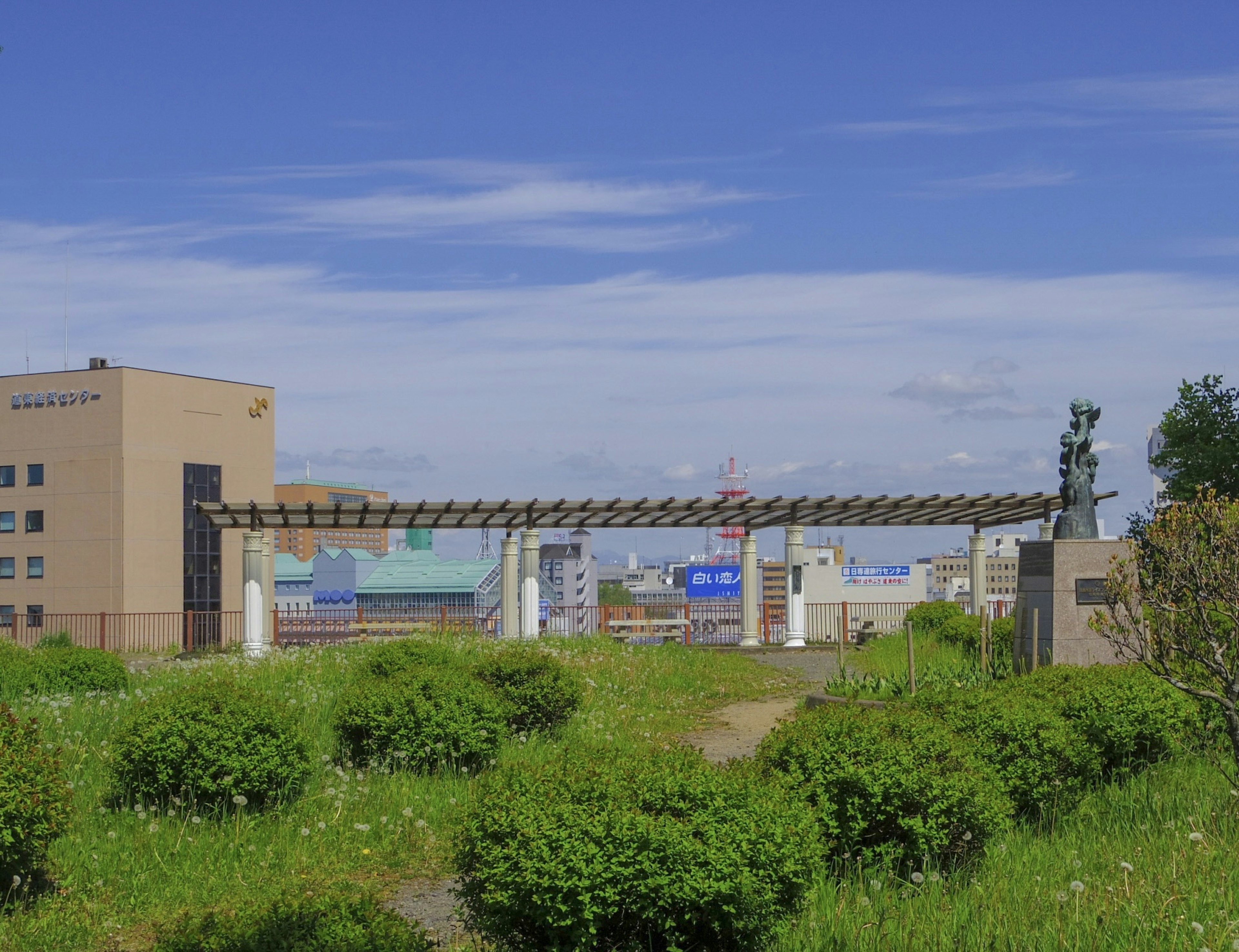 Un bâtiment et une porte entourés de verdure sous un ciel bleu