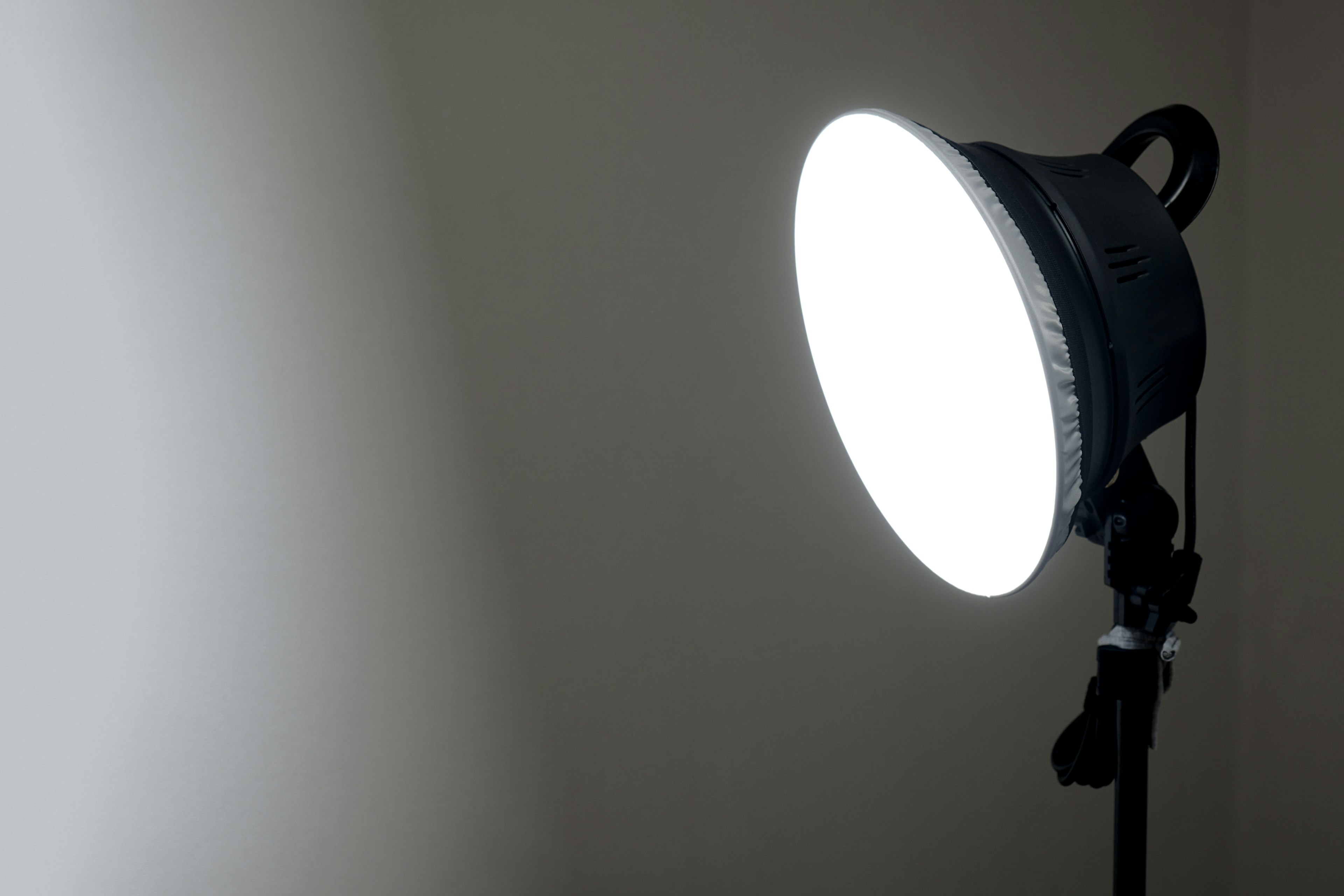 Luz brillante posicionada hacia una pared en un entorno minimalista