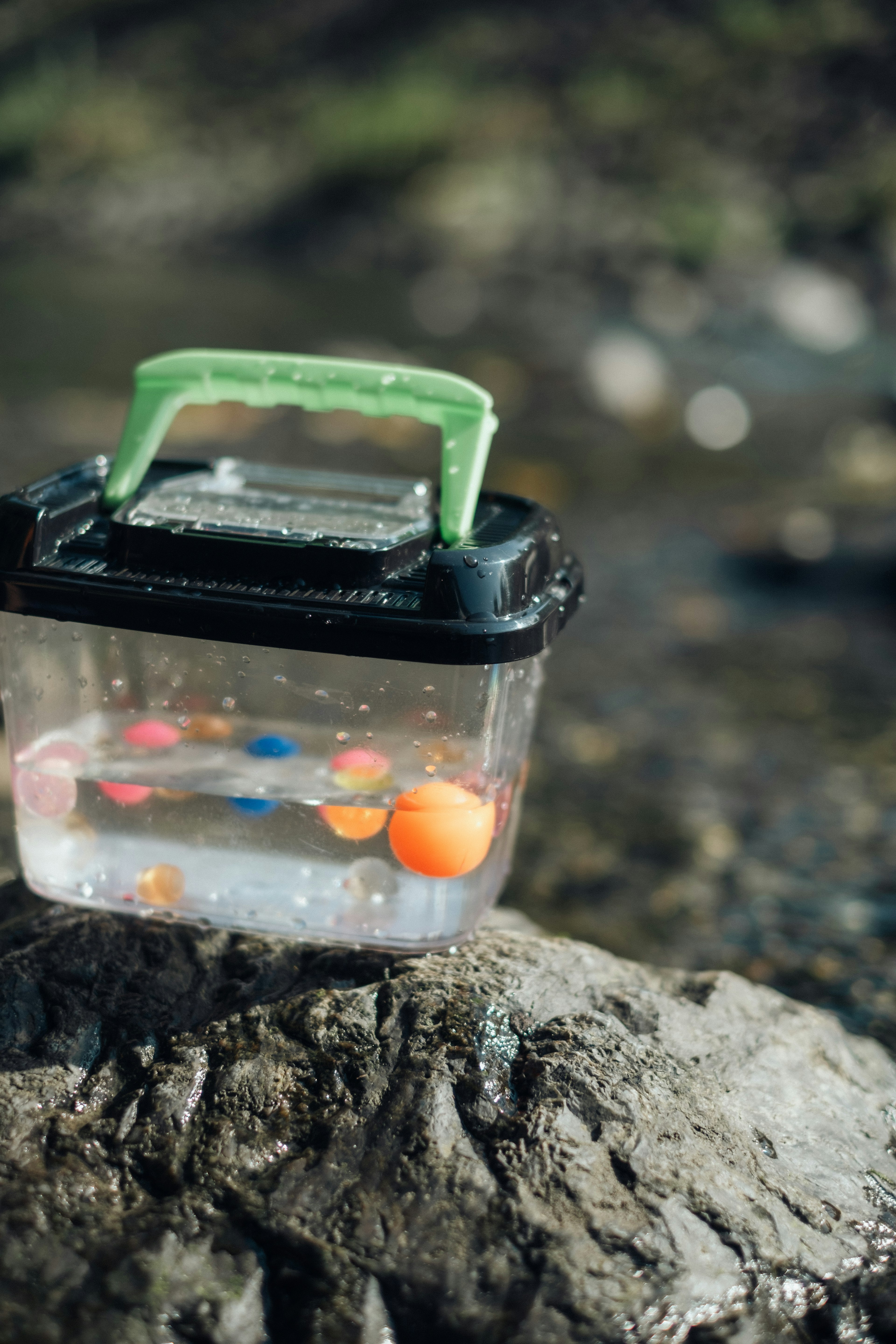 透明な容器に水とカラフルなボールが入っている