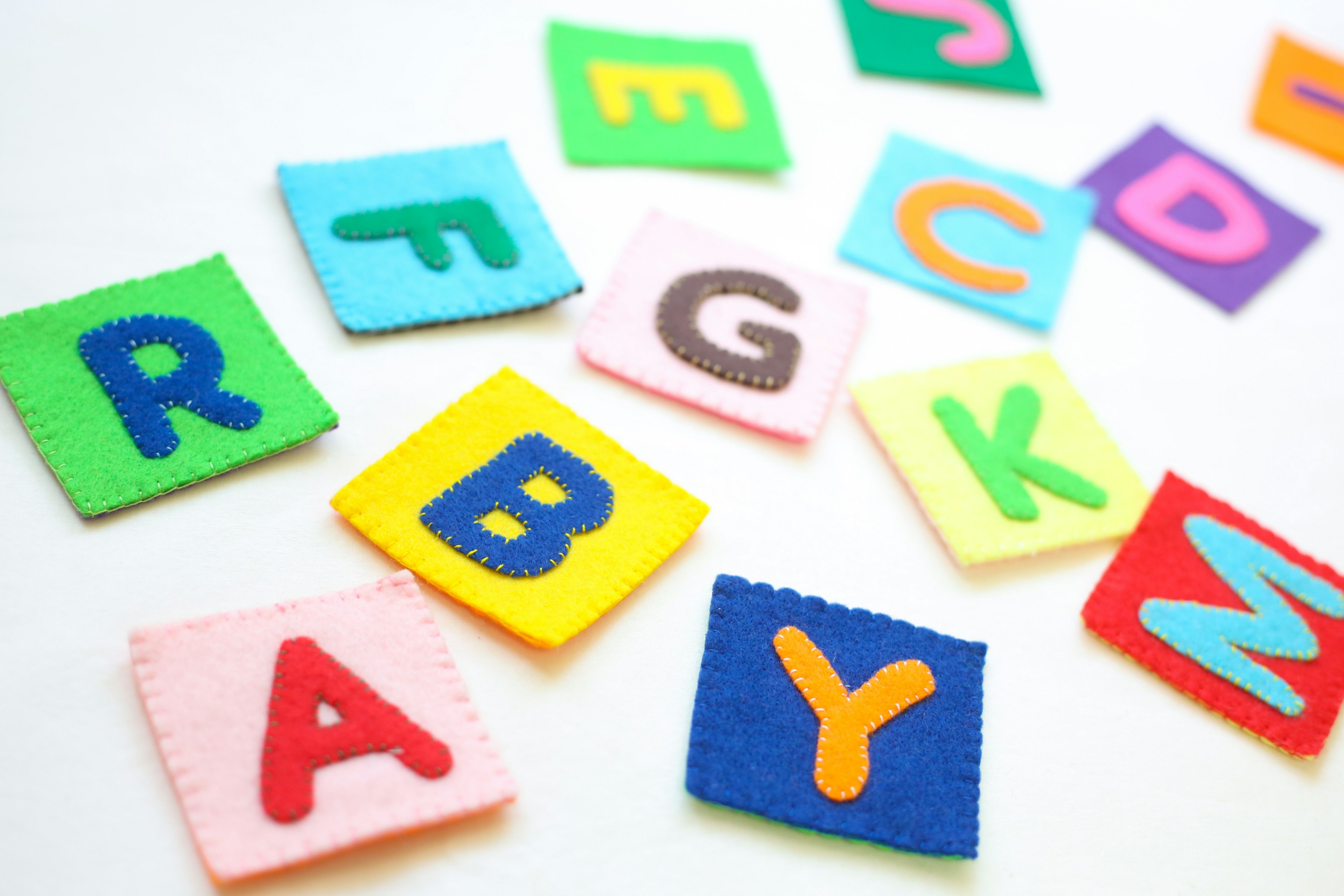 Colorful felt alphabet patches scattered on a surface