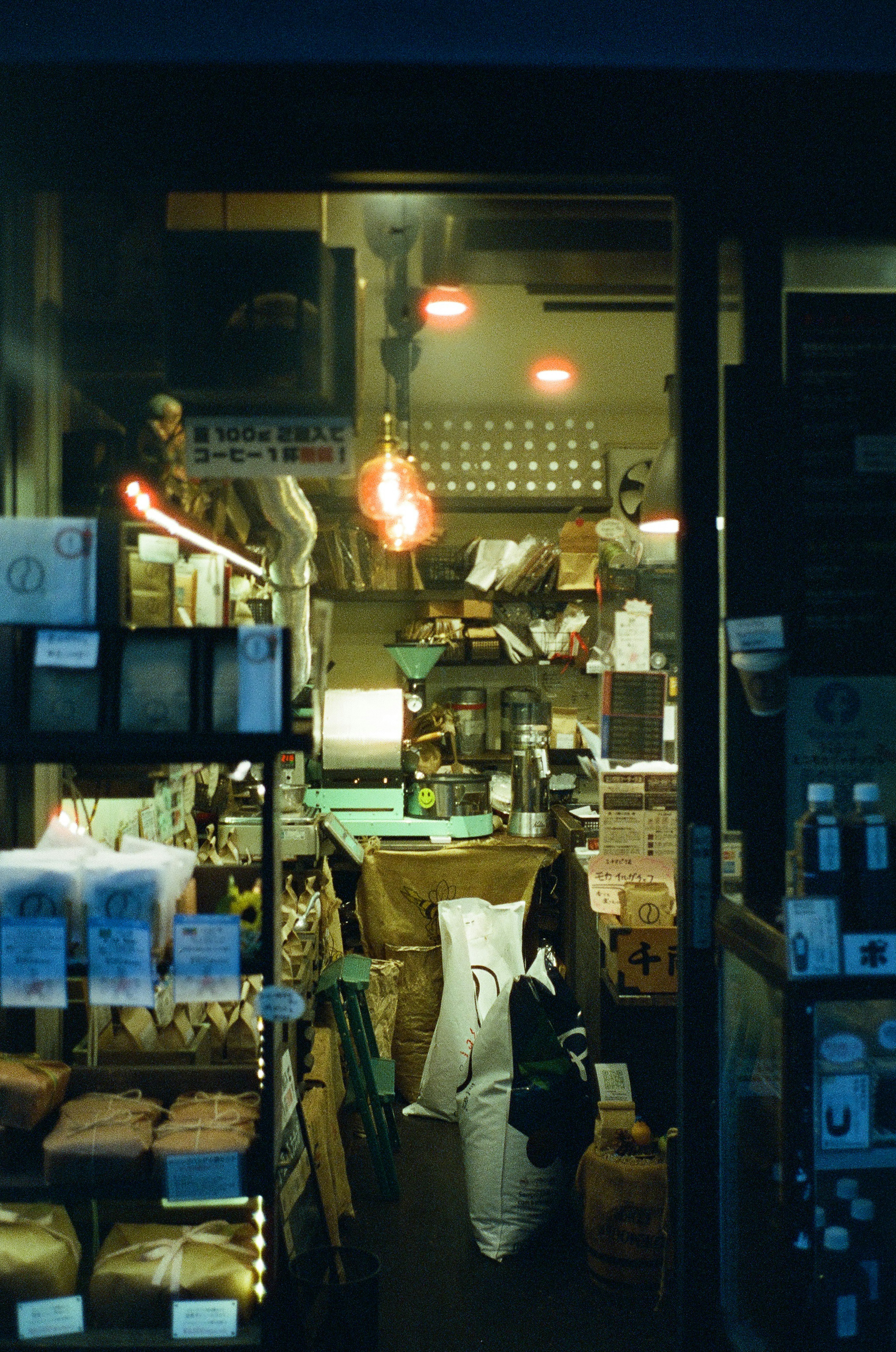 Interior de tienda débilmente iluminado con mercancías apiladas y luz cálida