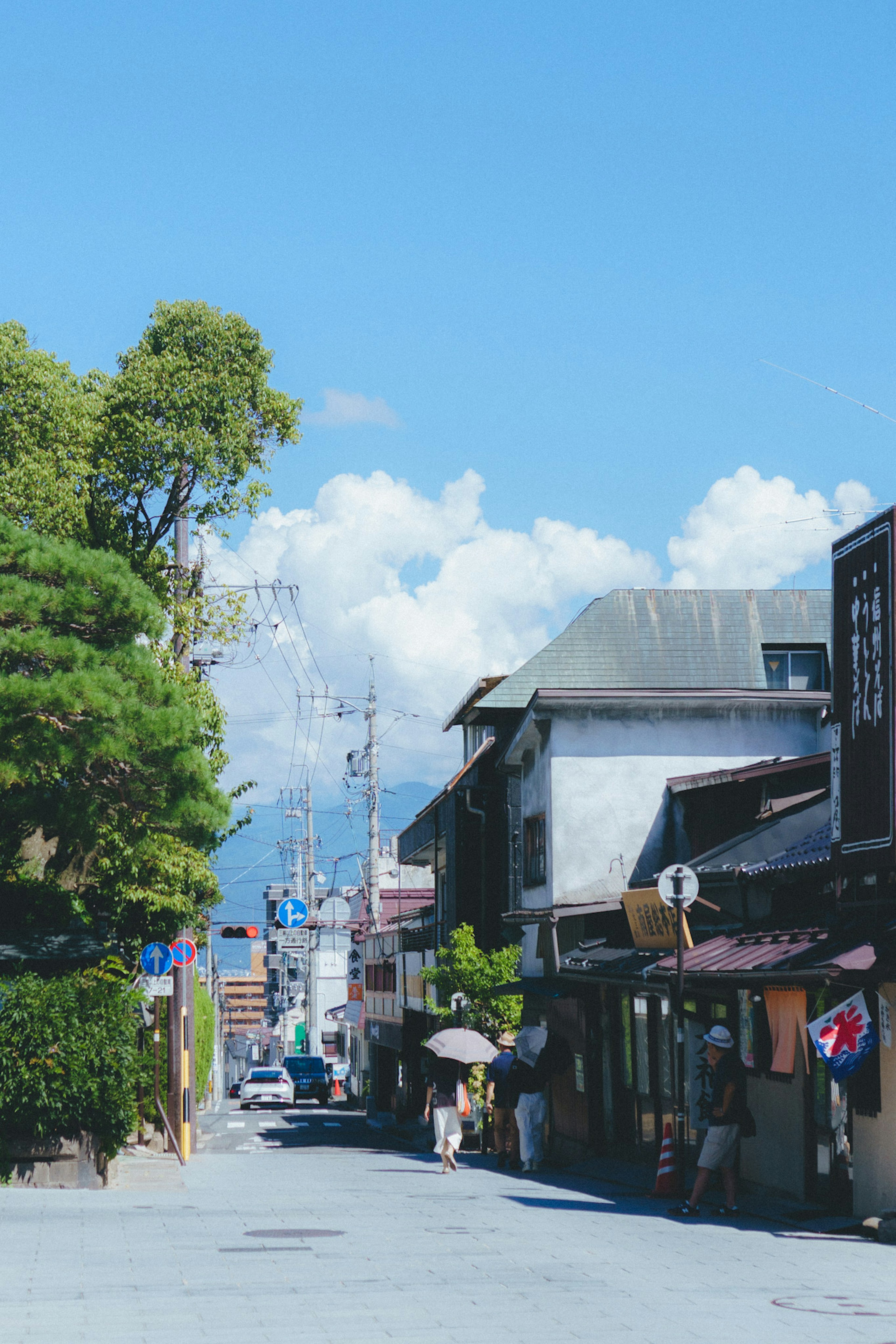 Scenic street view with historic buildings and people walking under blue sky