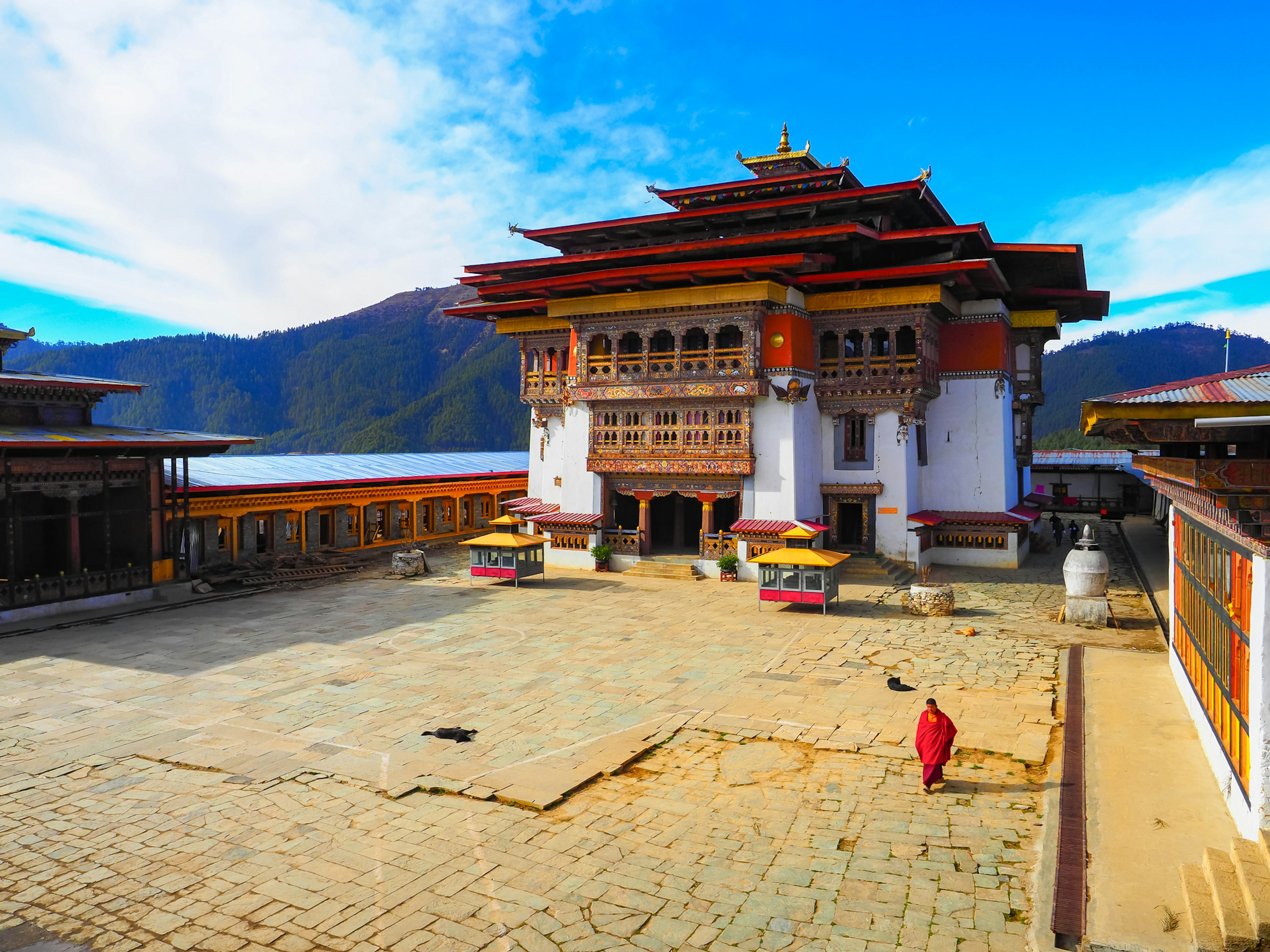 Traditioneller bhutanischer Tempel, umgeben von atemberaubenden Bergen mit einem geräumigen Innenhof