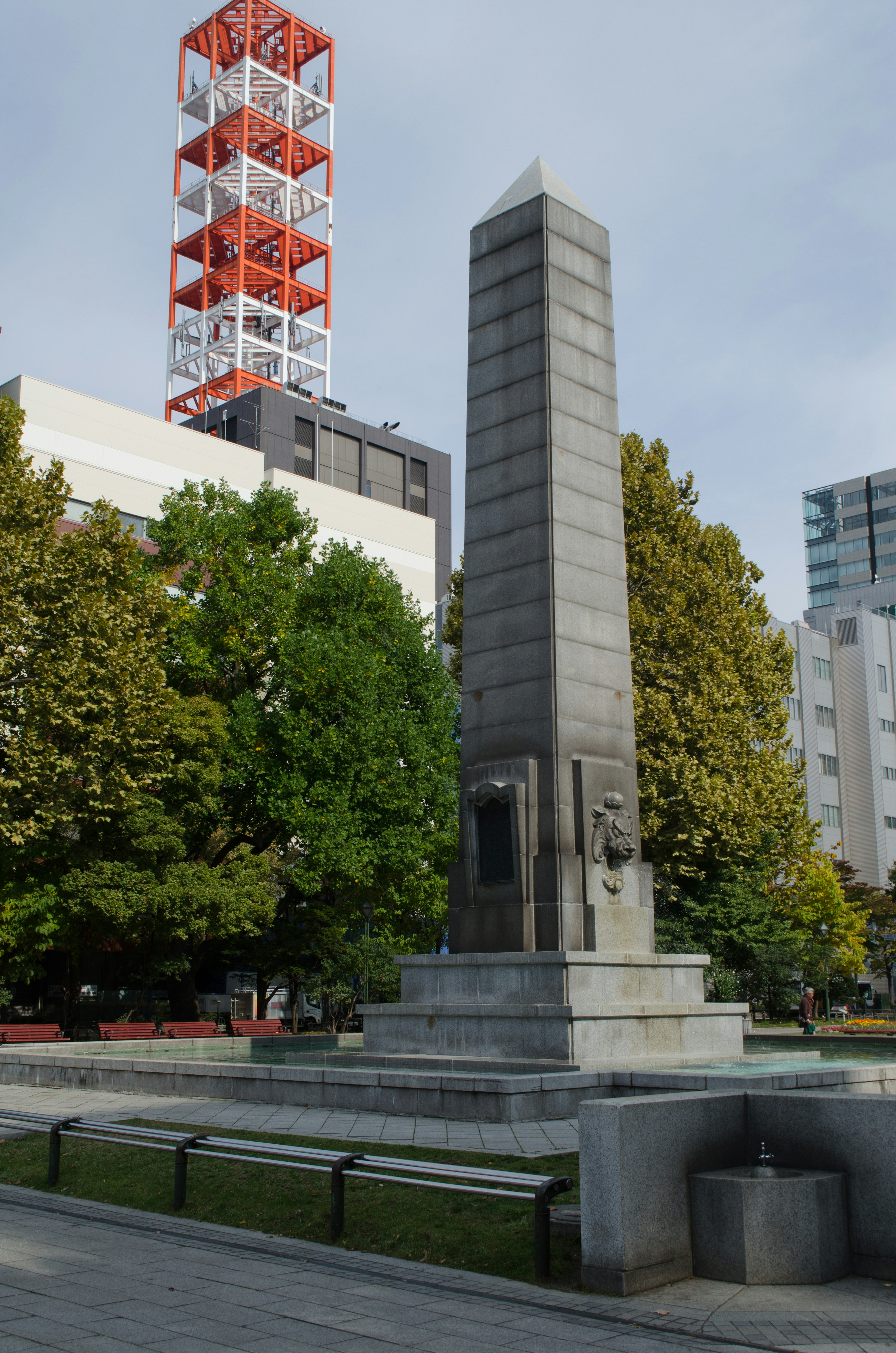 公園内に立つ高い石の記念碑と周囲の緑