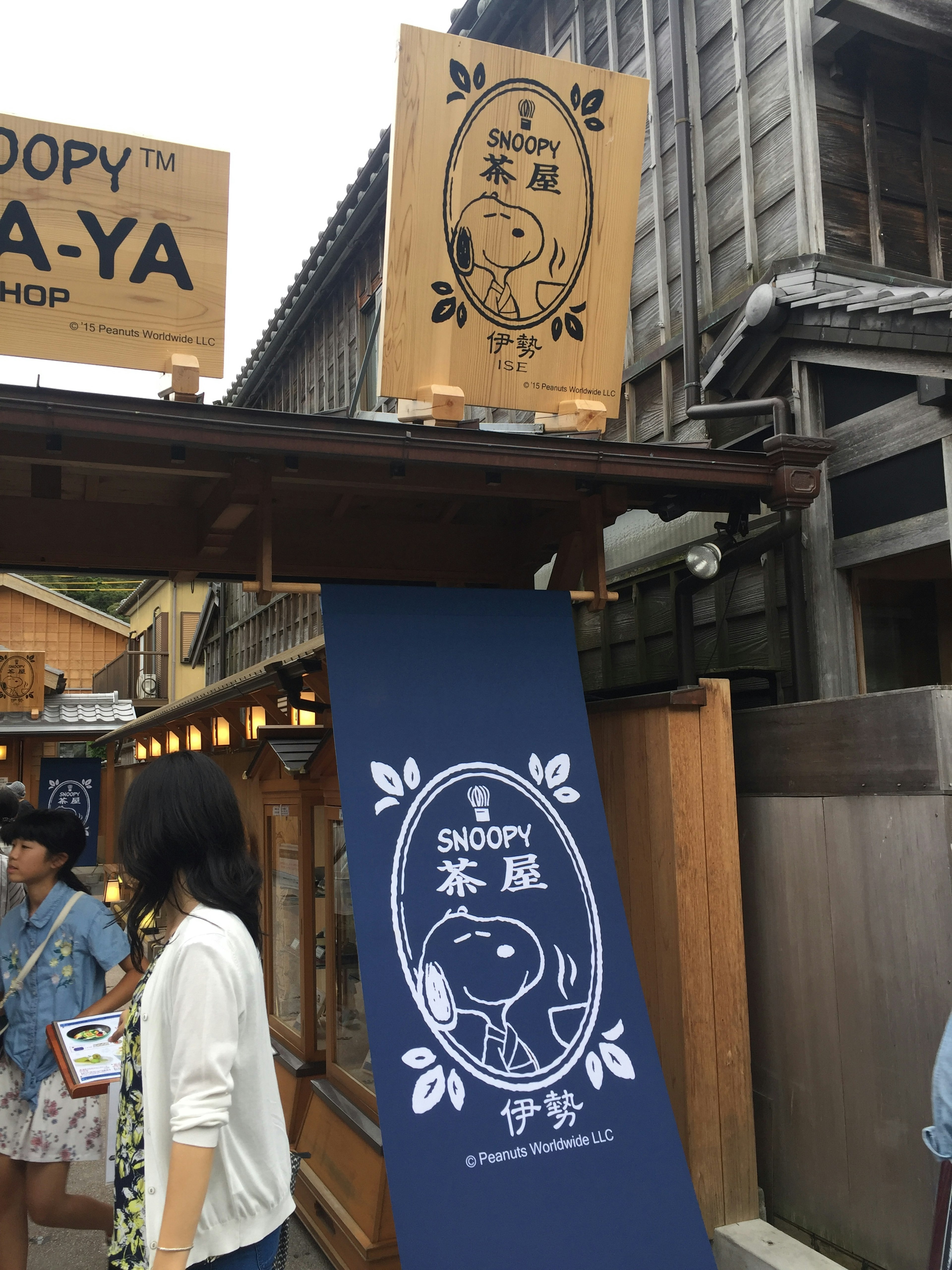 Exterior de una tienda con un letrero de Snoopy y una pancarta azul