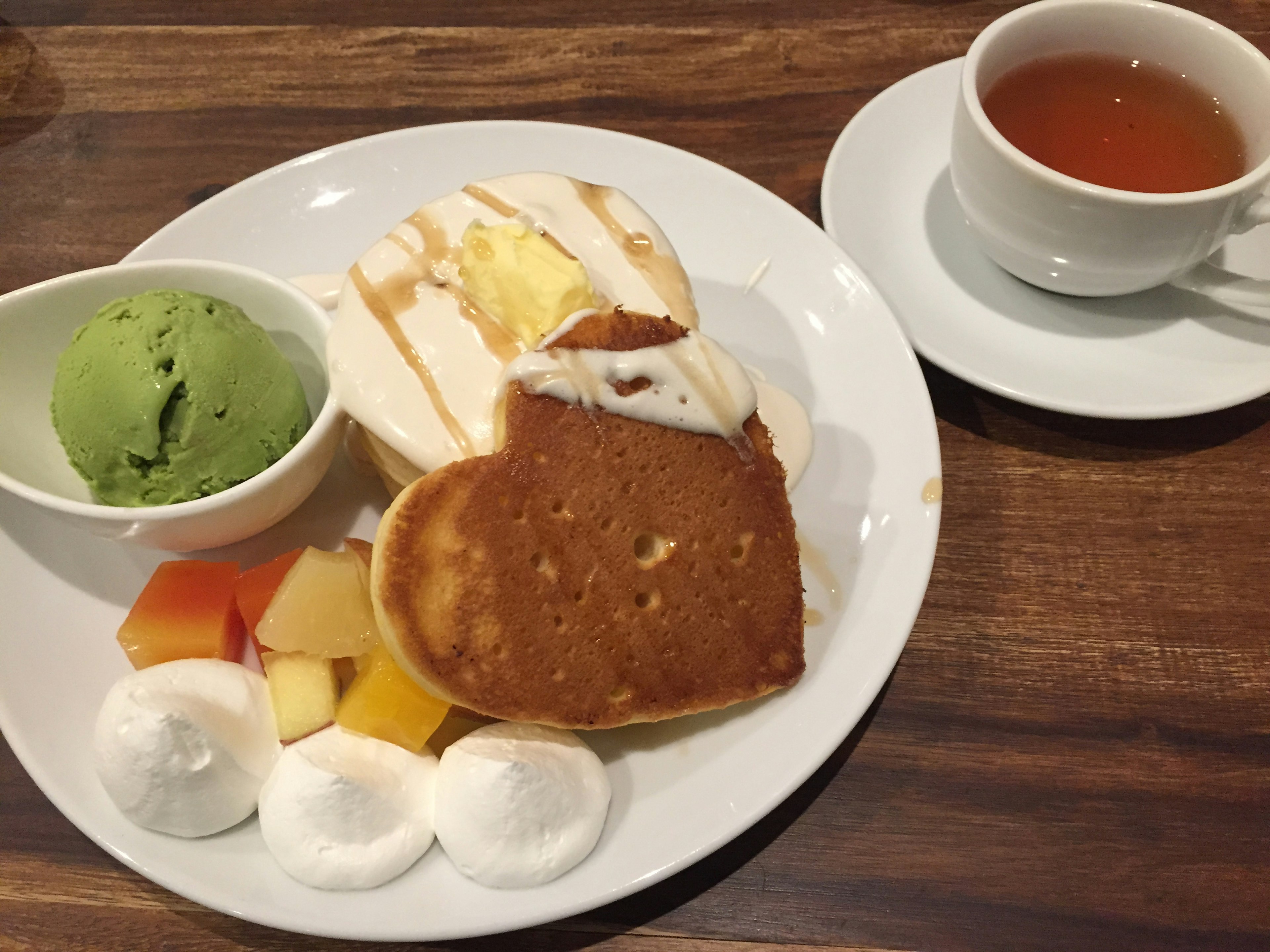 Plato de postre con helado de té verde y panqueque en forma de corazón