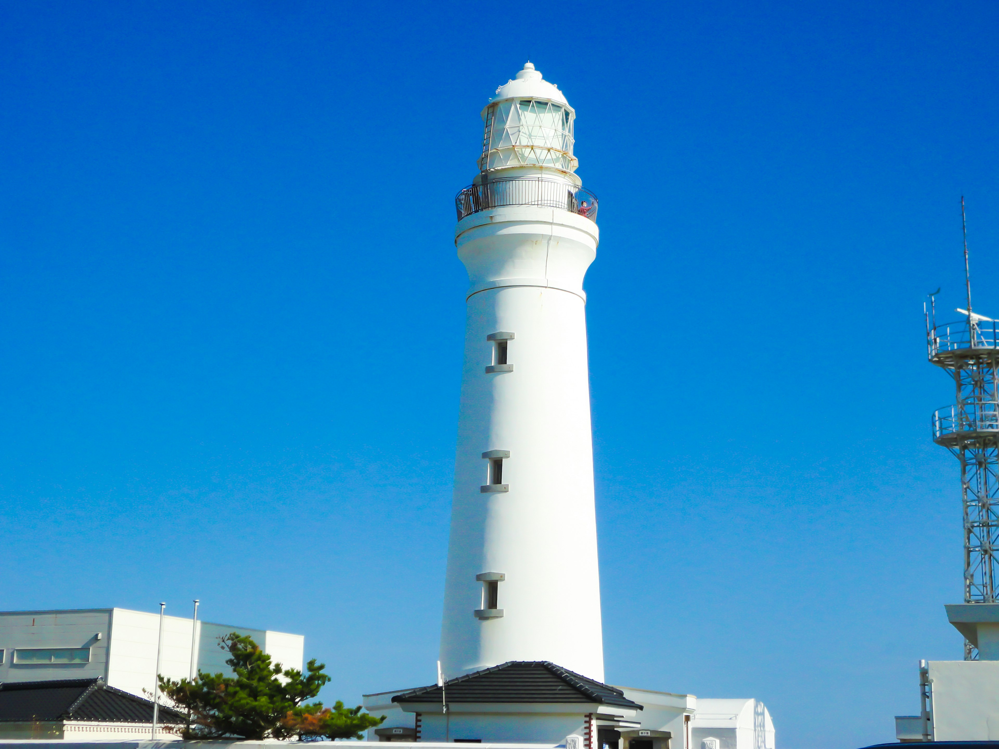 White lighthouse standing under a blue sky