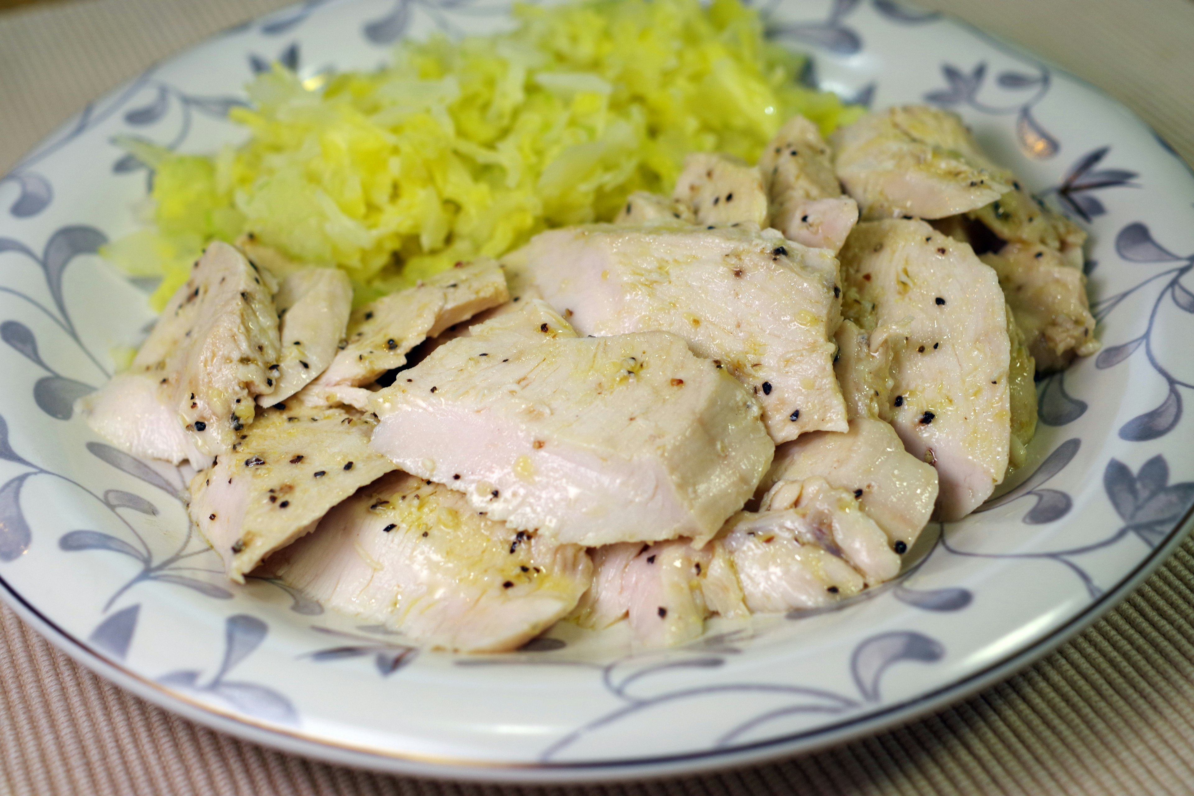 Sliced chicken served with shredded cabbage on a decorative plate