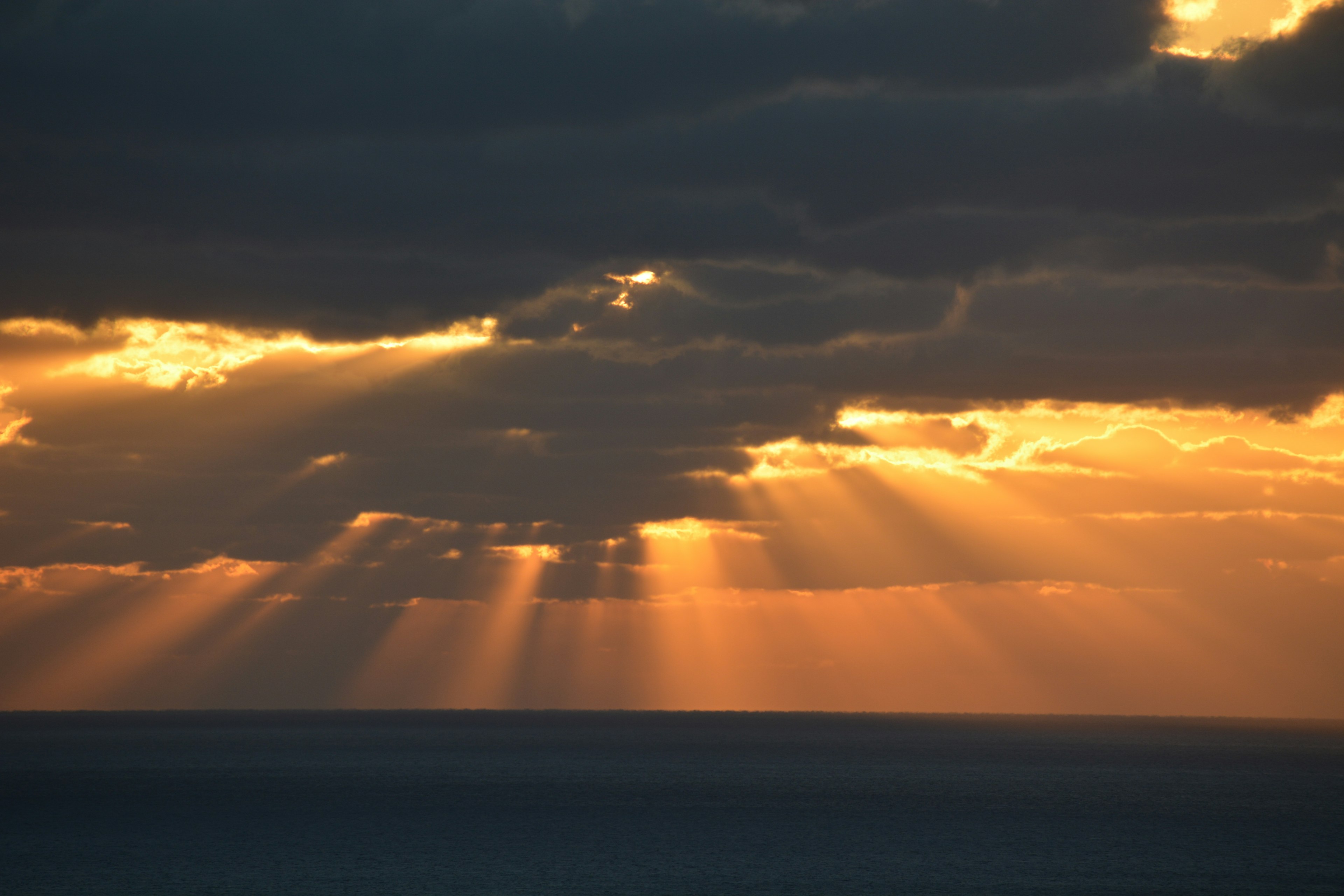 Nubes iluminadas por la luz dorada del sol sobre el océano