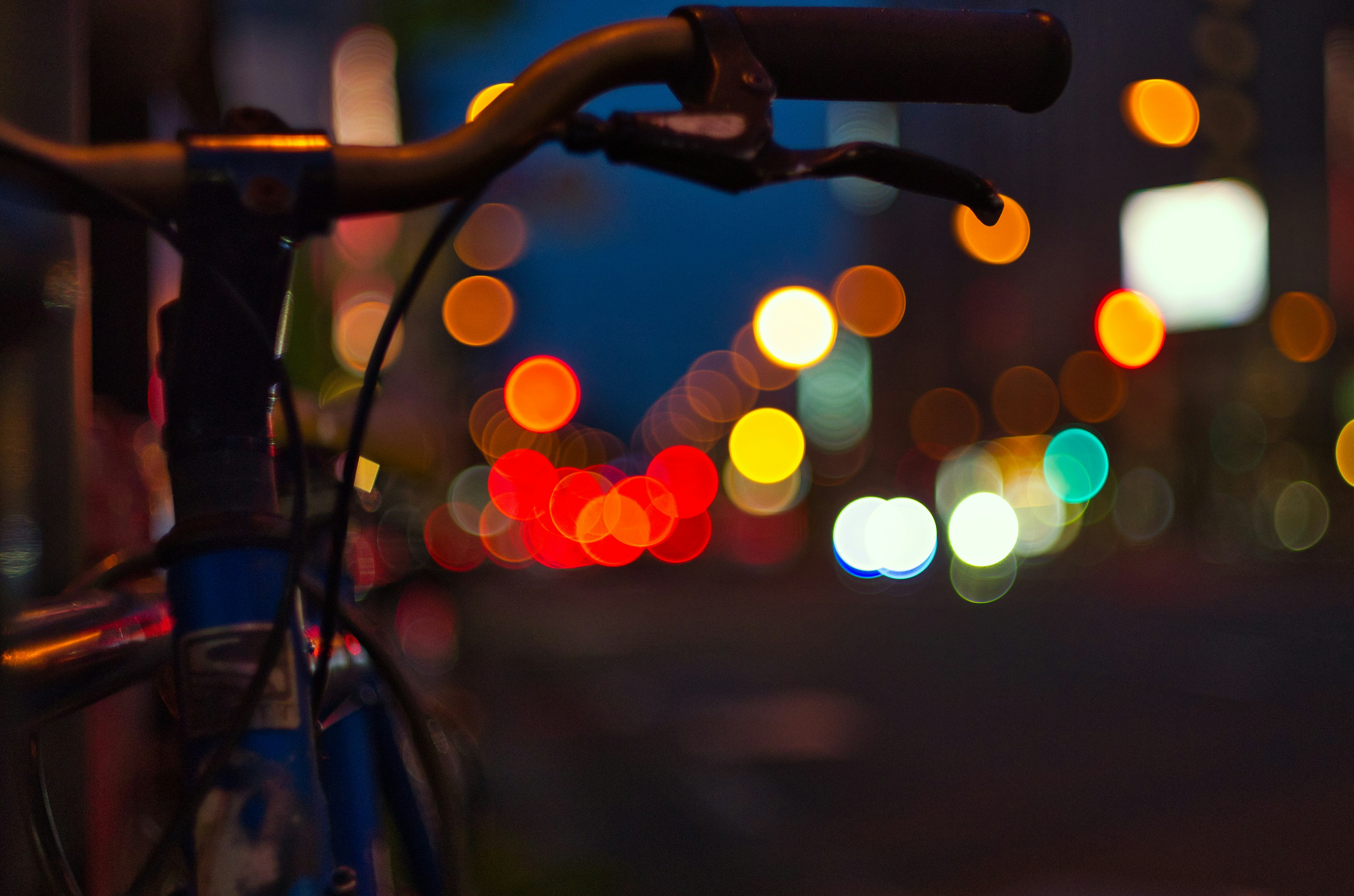 夜の街のぼやけた自転車のハンドルと光の玉