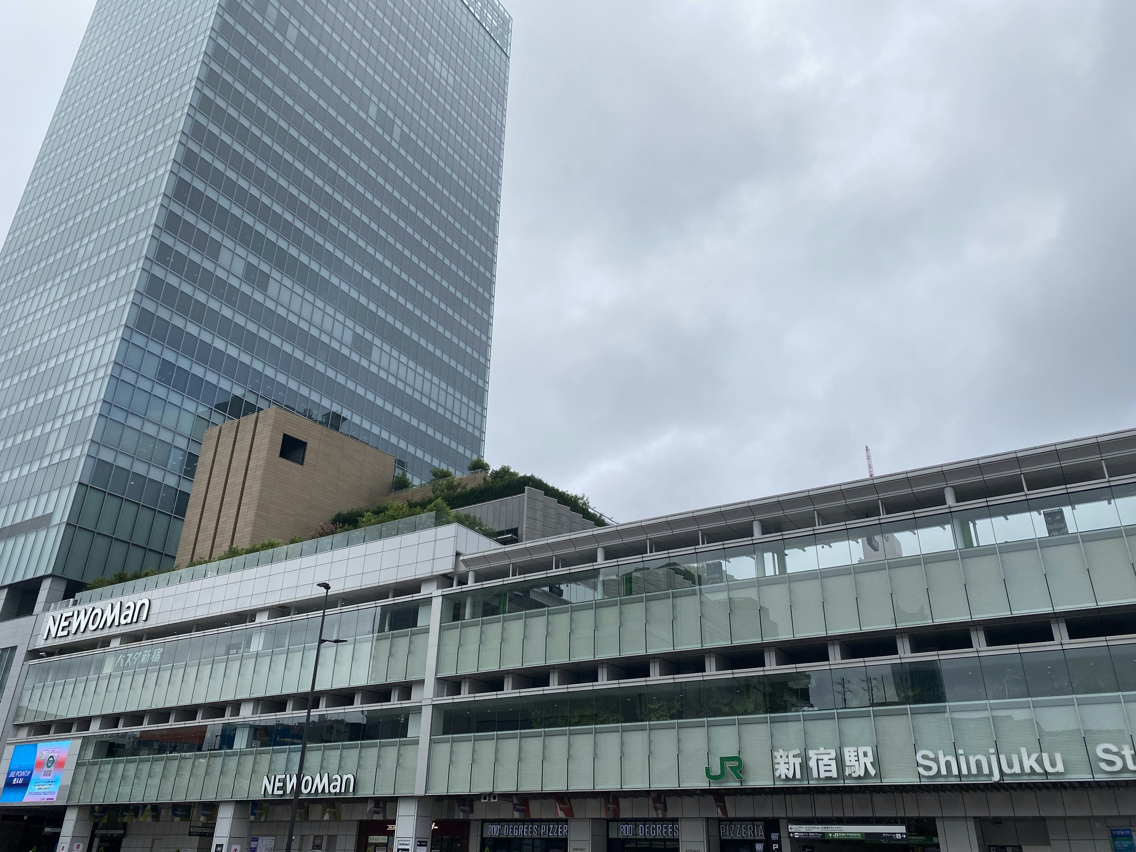 Blick auf das Gebäude des Shinjuku-Bahnhofs und die umliegenden Wolkenkratzer an einem bewölkten Tag