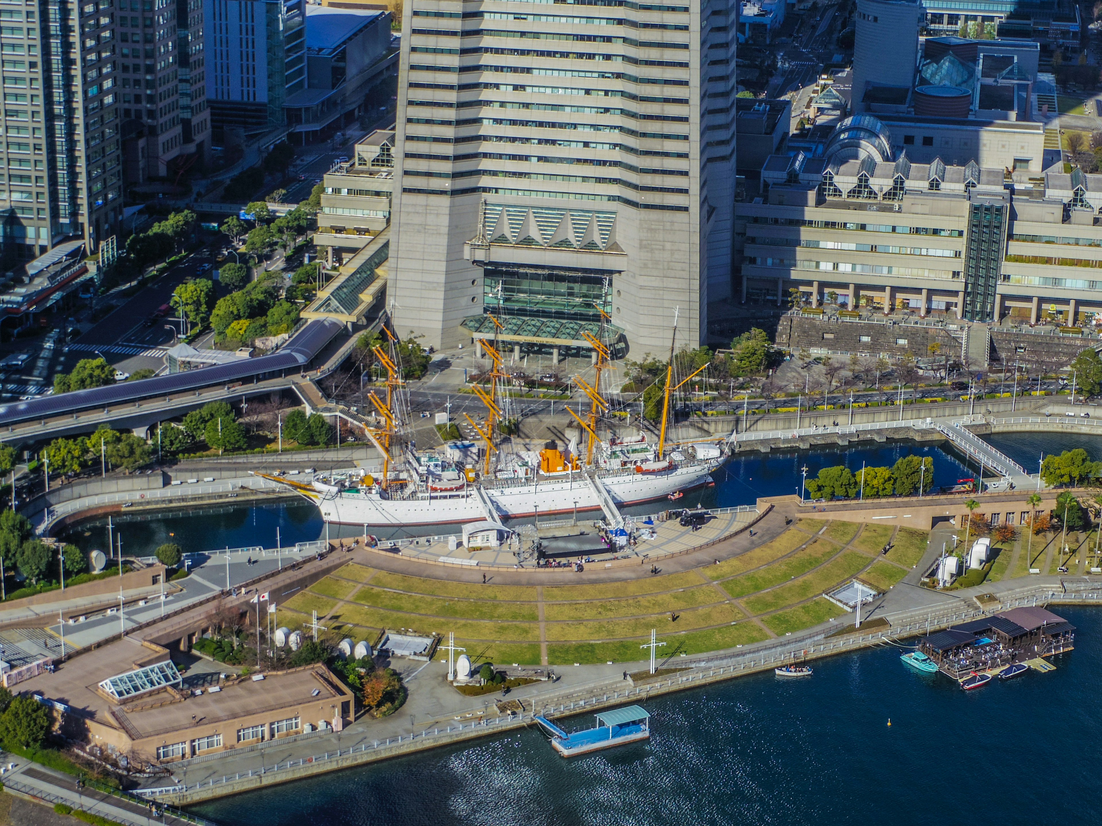 Aerial view of a park surrounded by skyscrapers with a ship docked