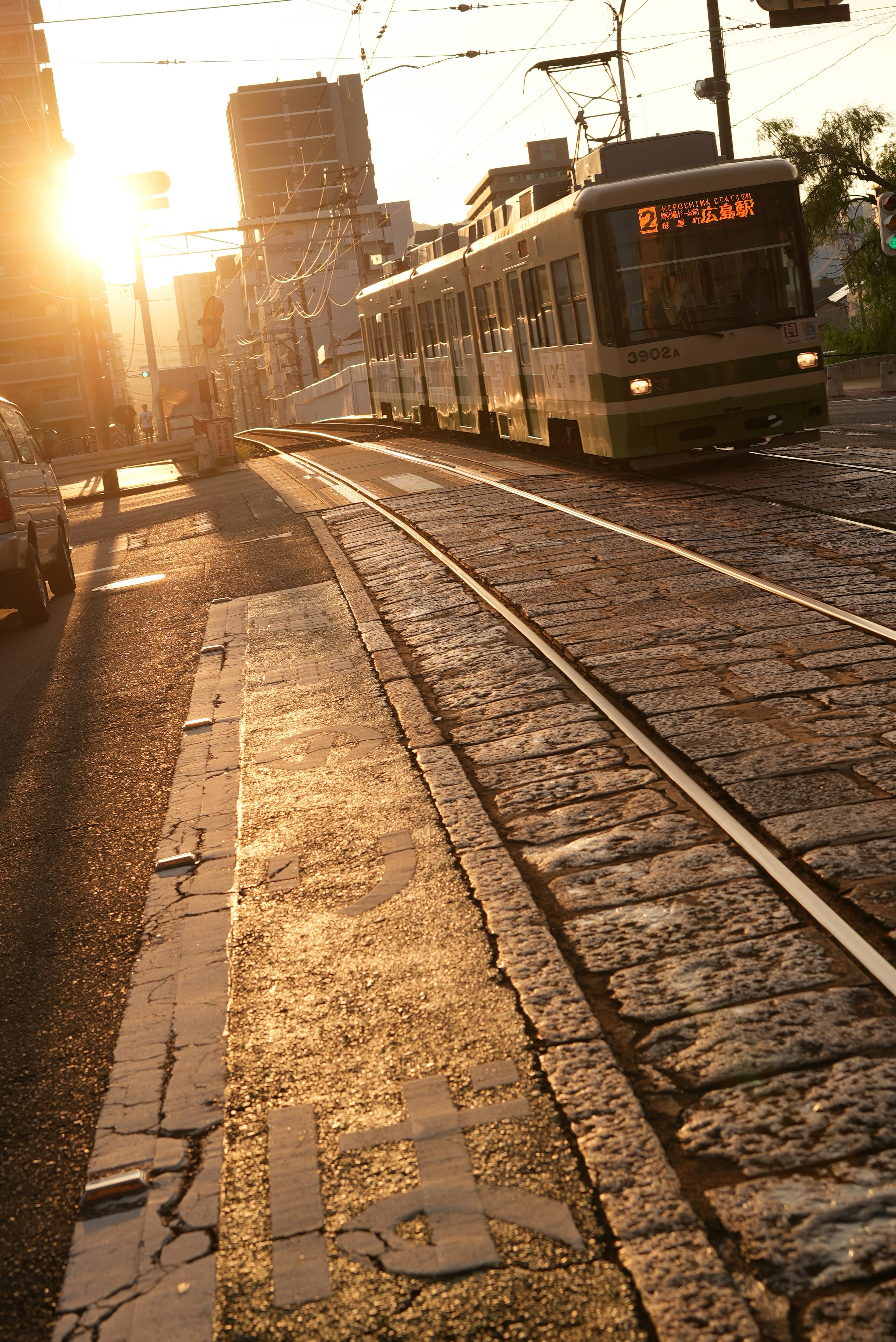 夕陽下在鵝卵石街道上行駛的電車