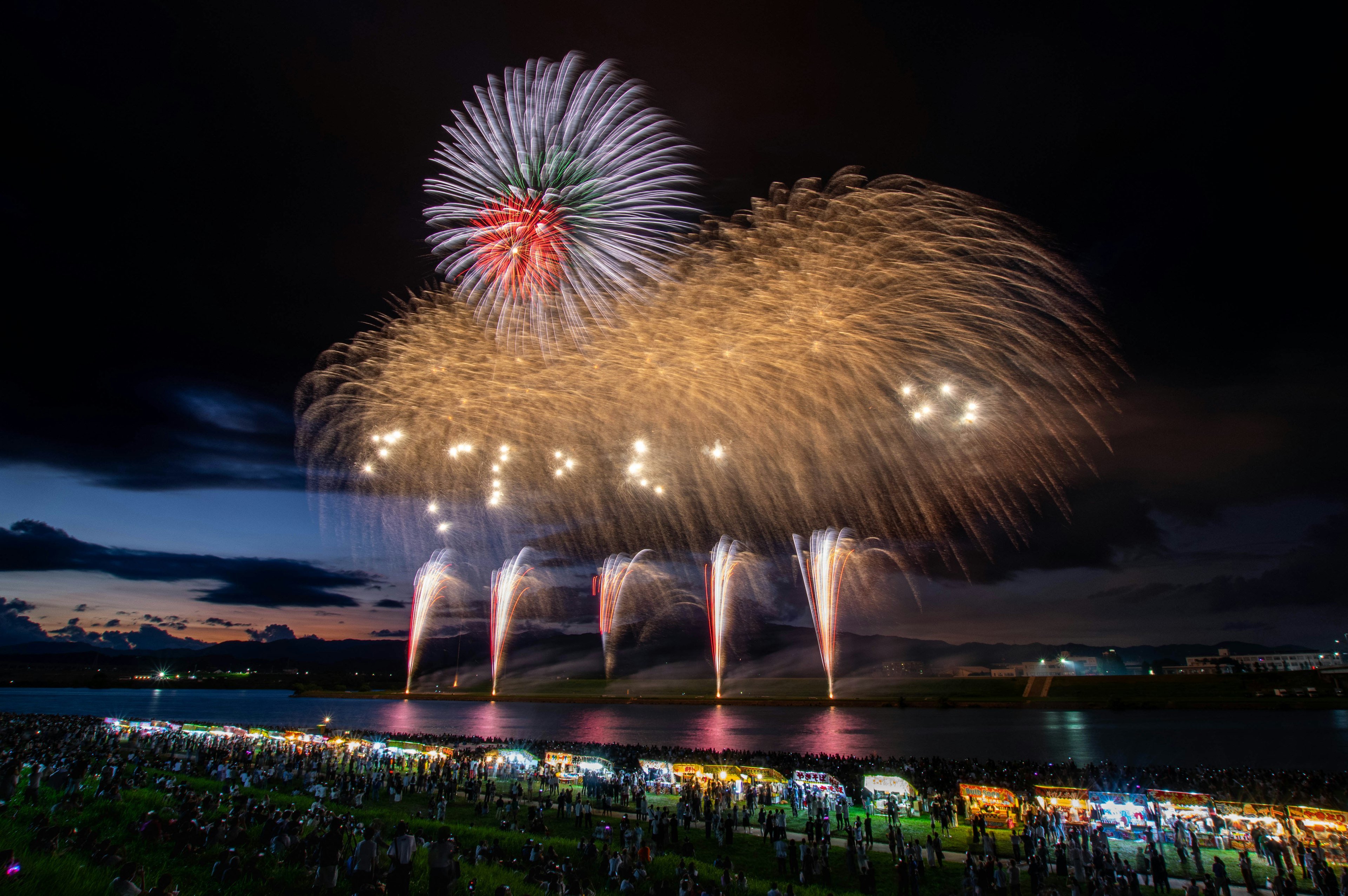 Colorful fireworks display in the night sky with spectators