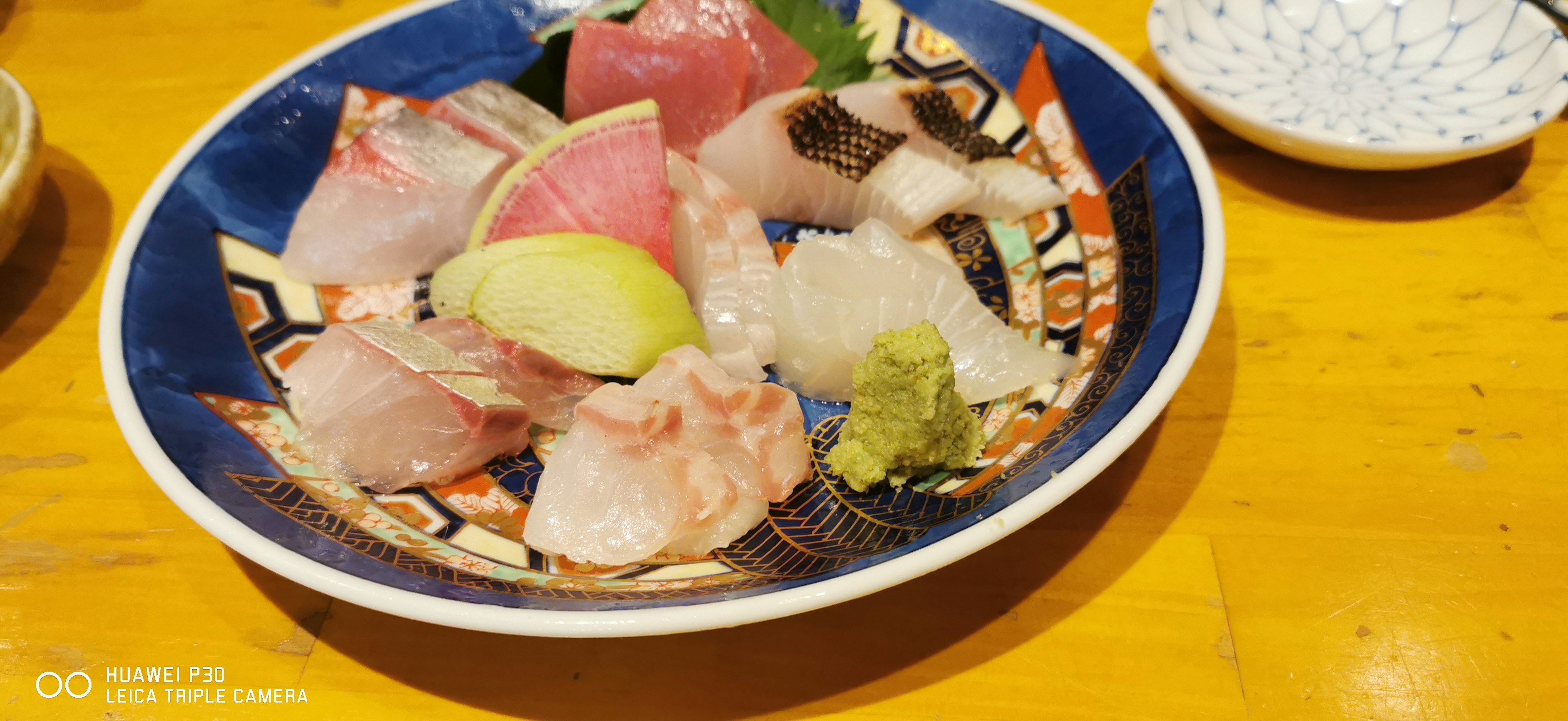 A colorful sashimi platter served in a blue bowl