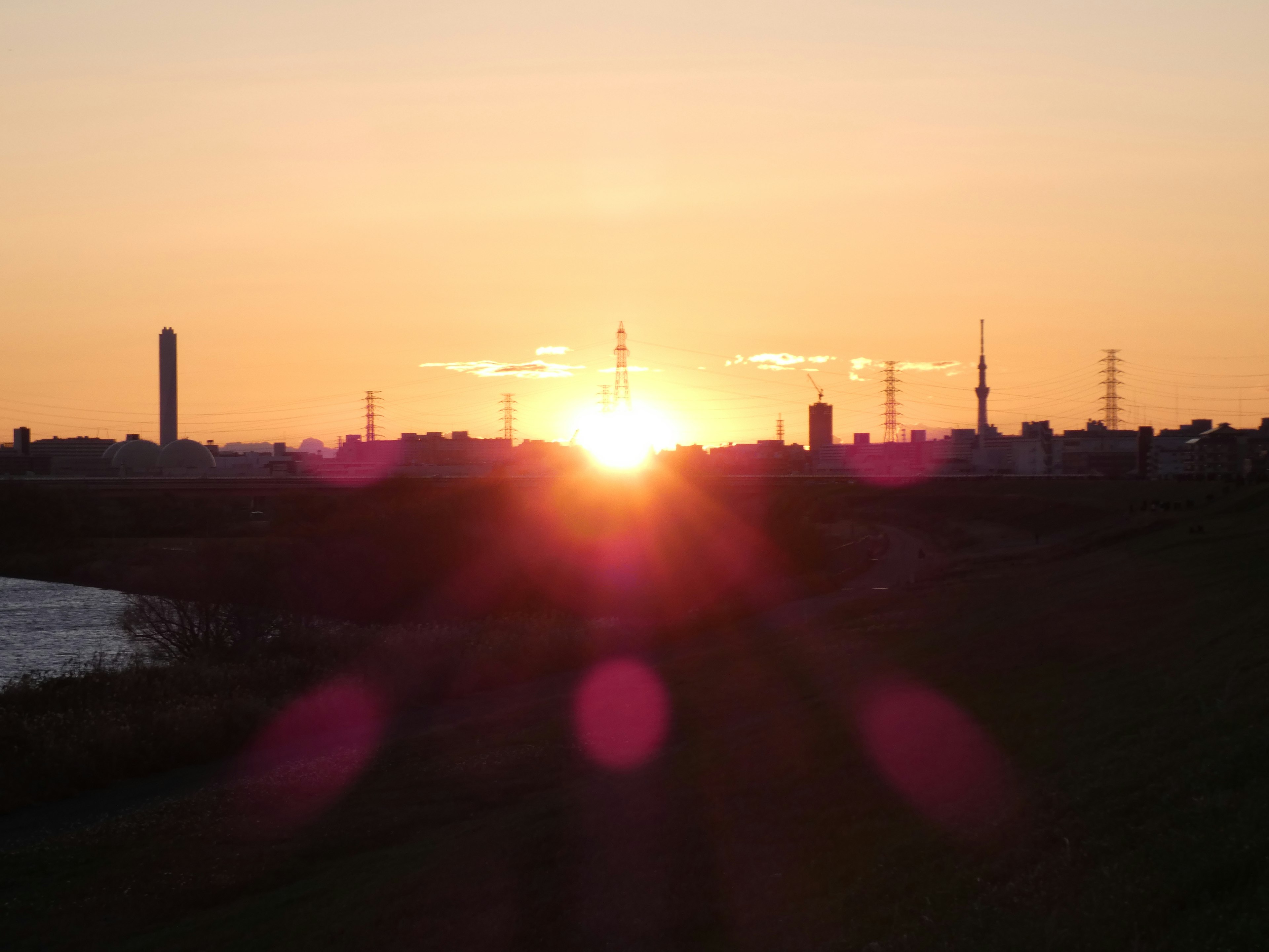 Vista del tramonto con edifici e torri in silhouette