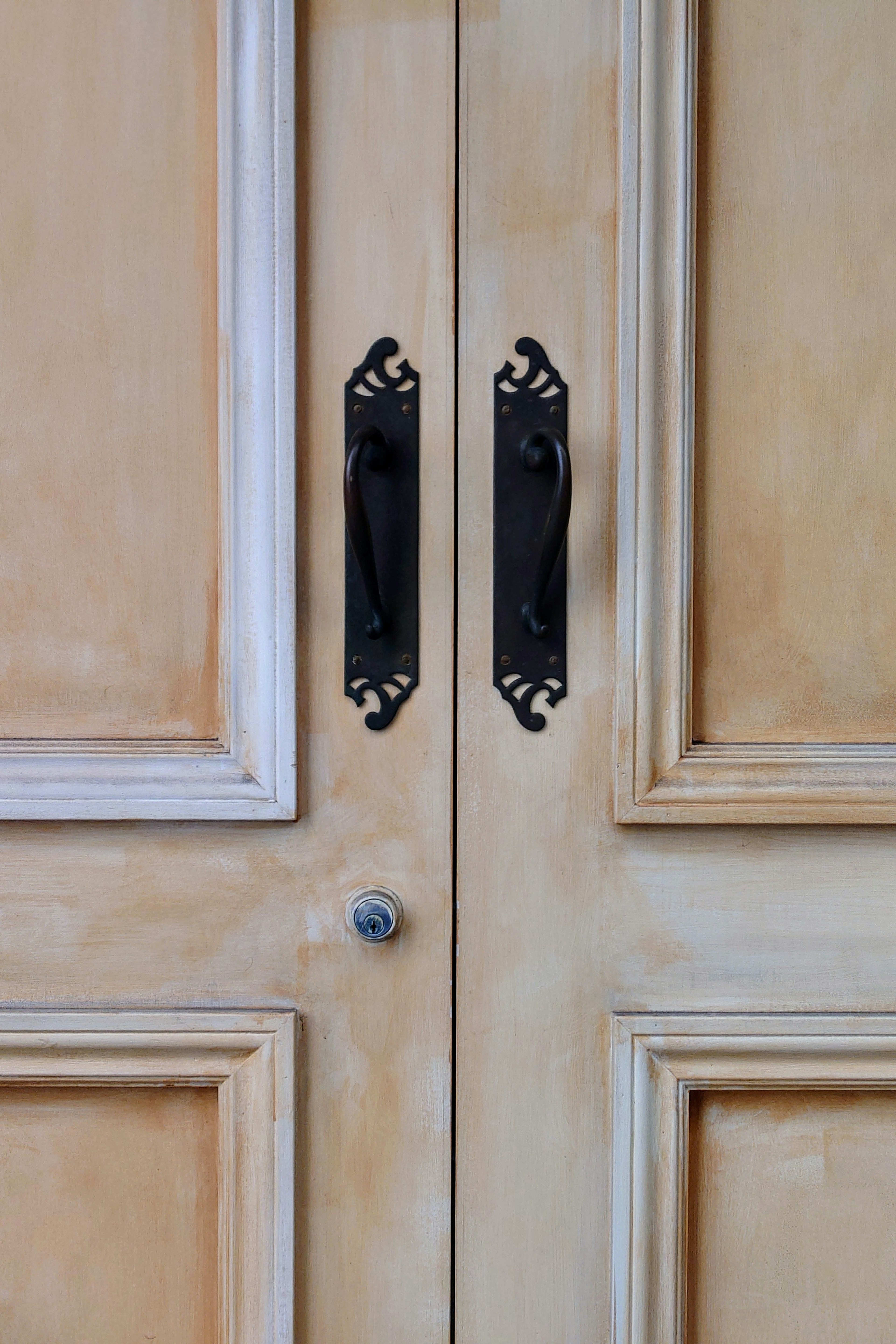 Detailed image of a wooden door featuring two decorative black handles