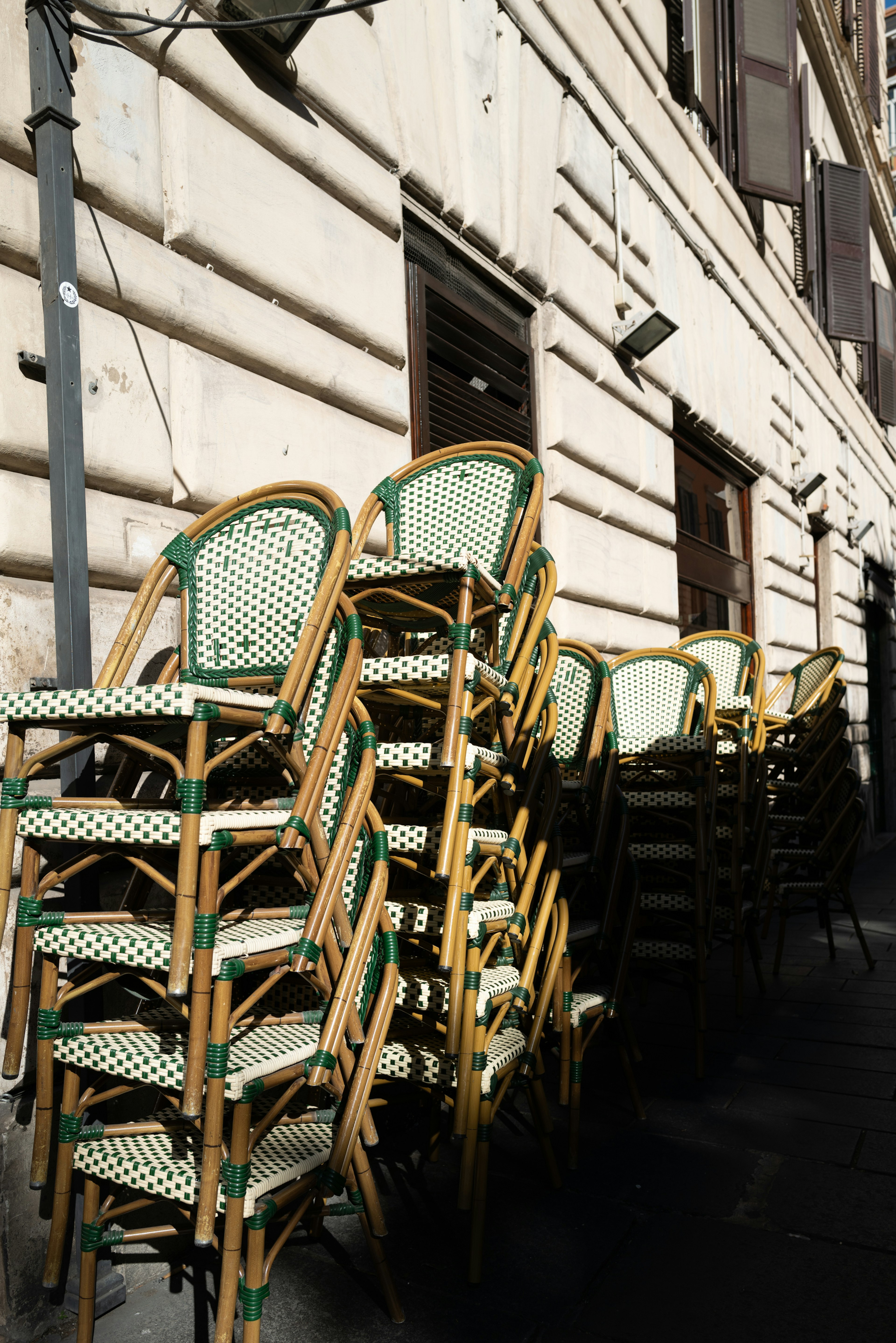 Sillas de café apiladas junto a un edificio