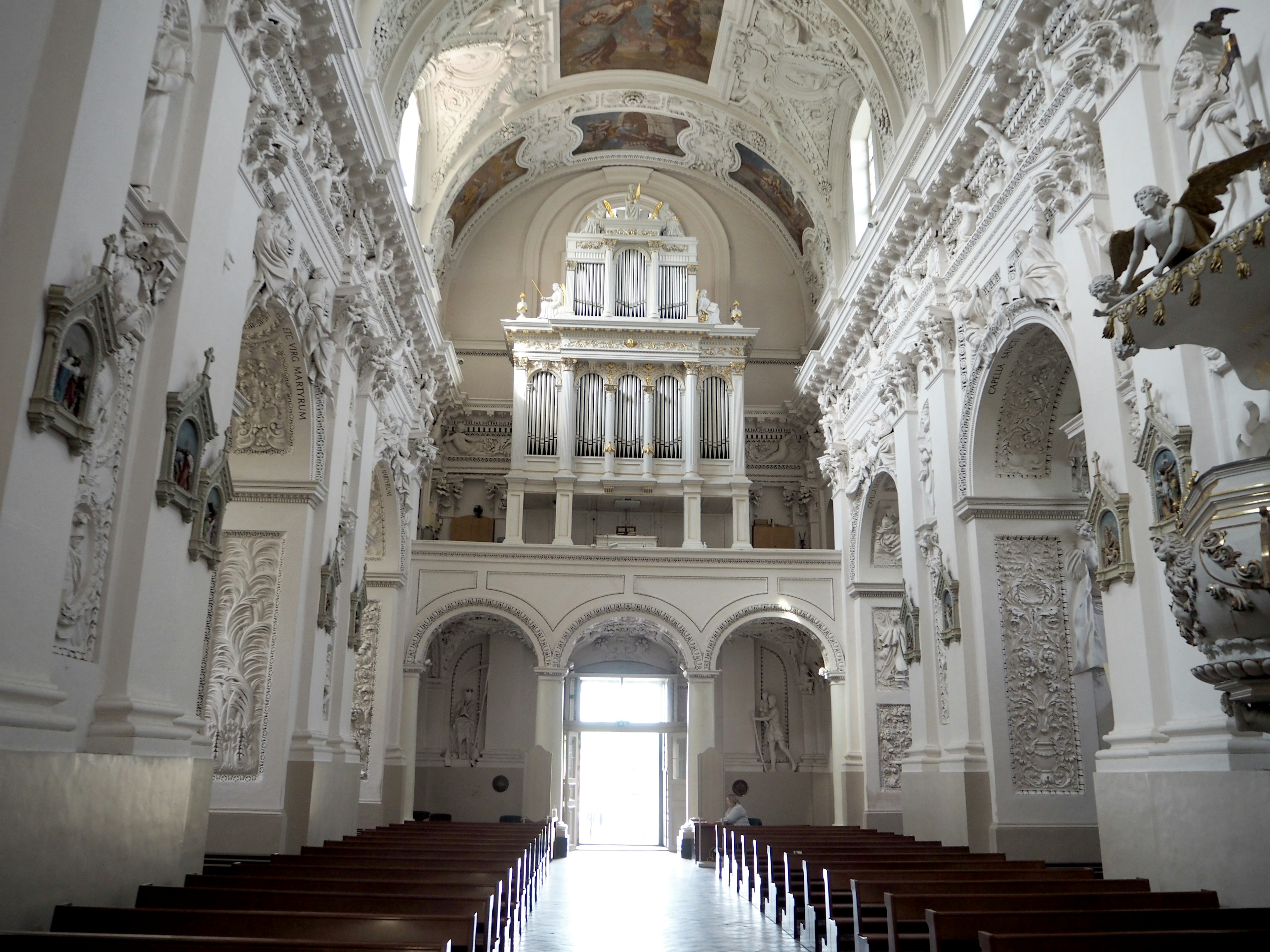 Innenraum einer Kirche mit weißen Wänden und dekorativen Skulpturen