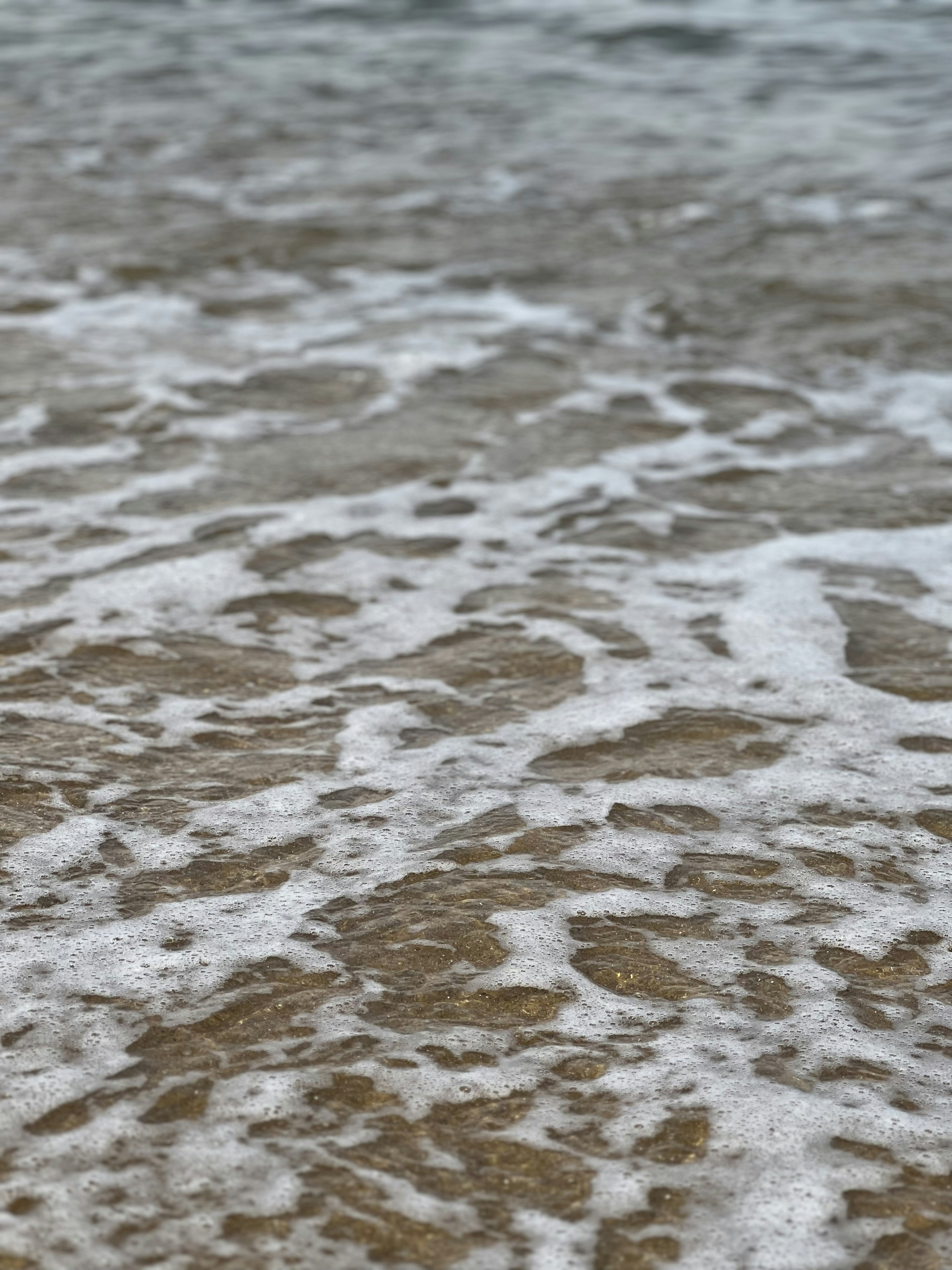 Acercamiento de la superficie del agua del océano con olas y espuma