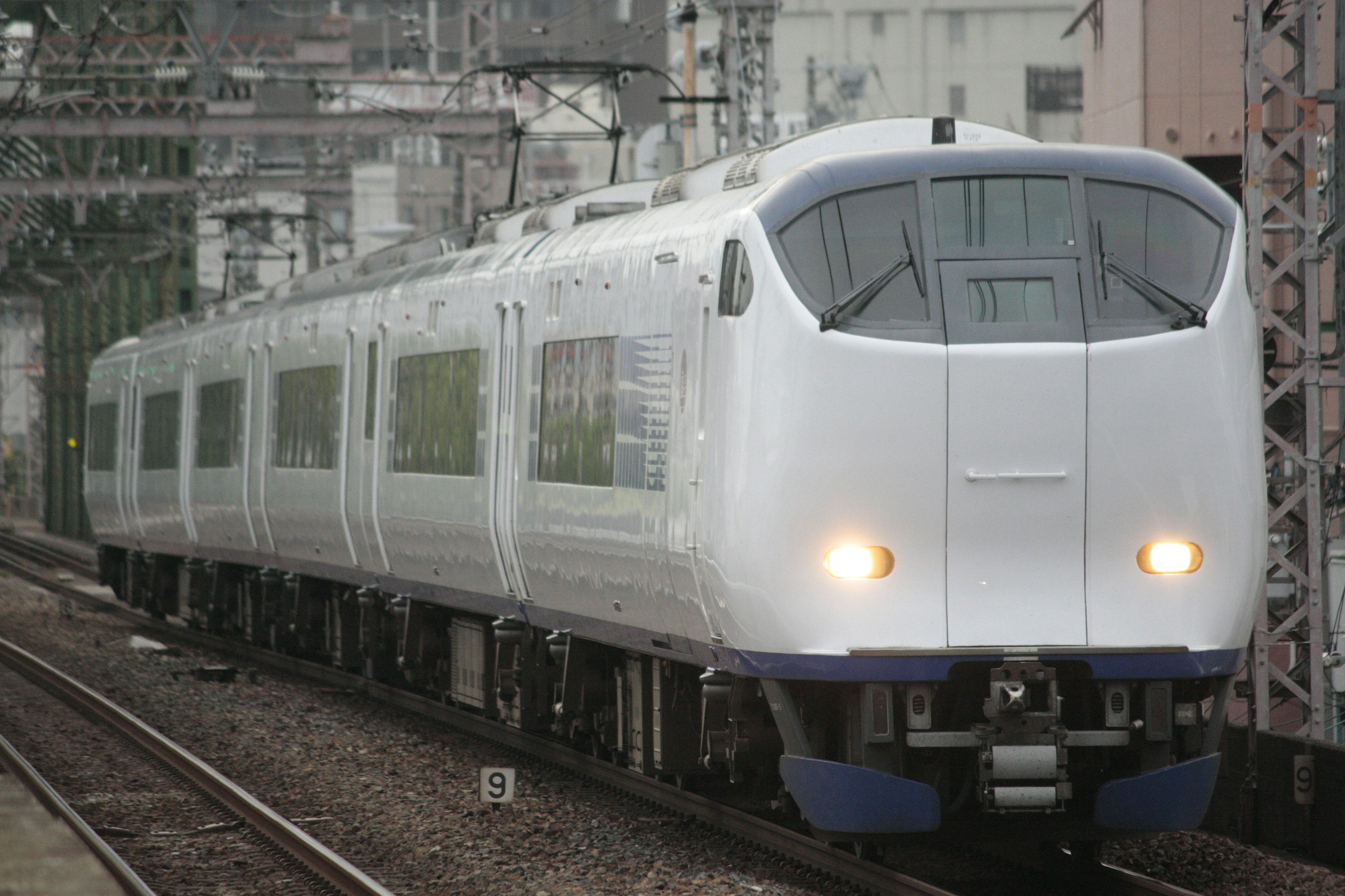 Un train express à carrosserie blanche est arrêté à une gare