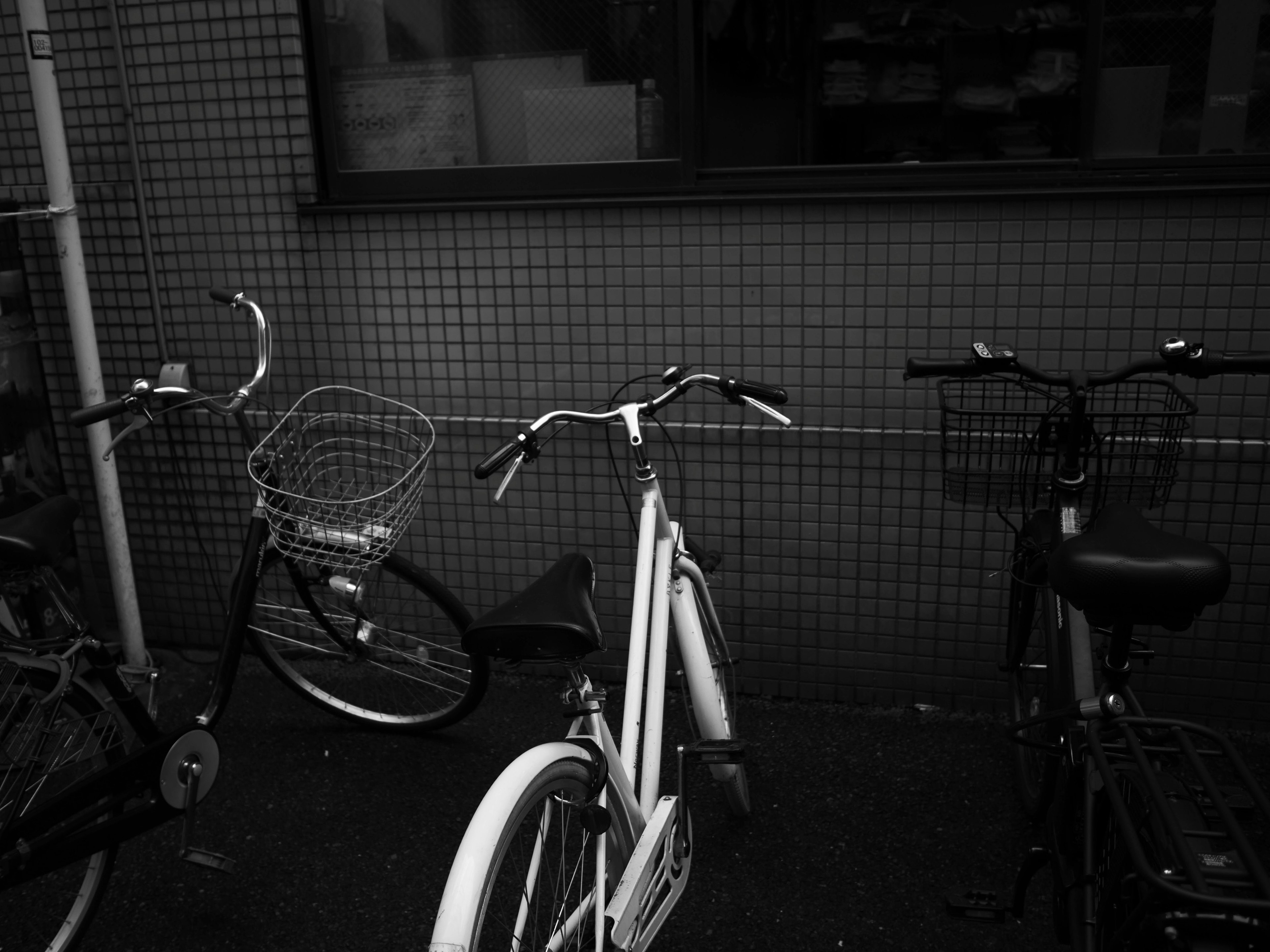 Escena con una bicicleta blanca y una bicicleta negra con una bicicleta de cesta larga visible