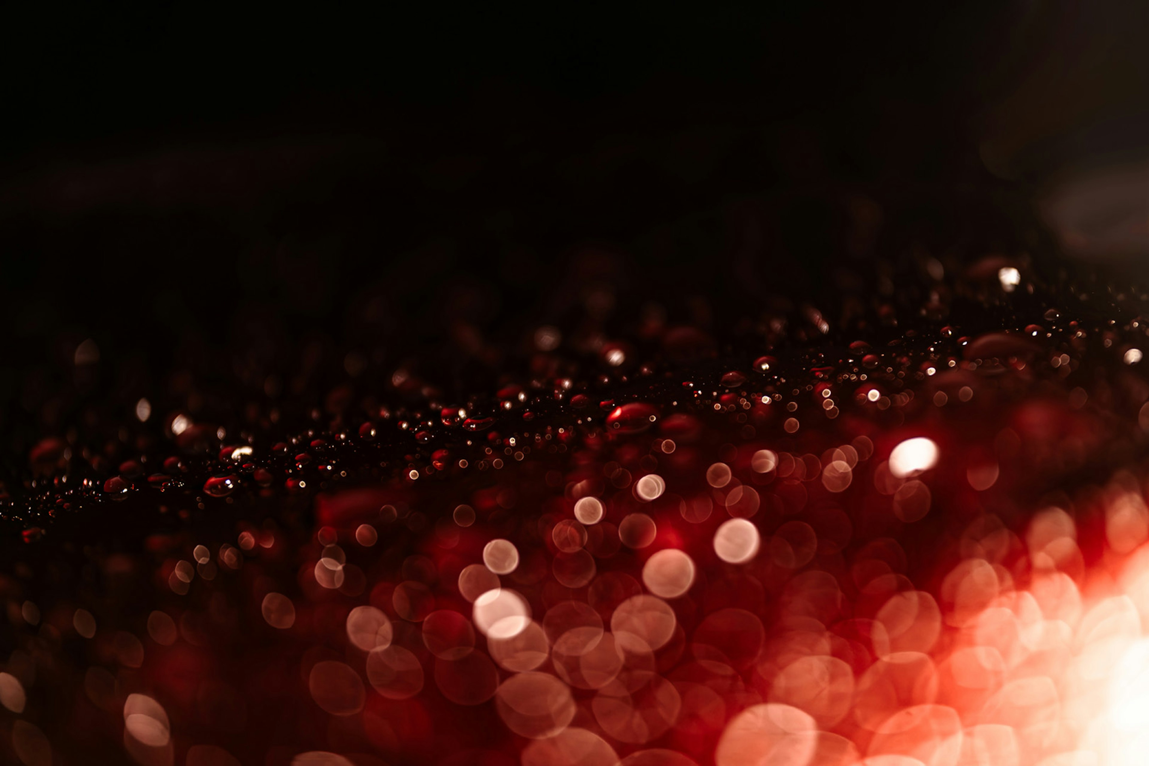 A close-up of shimmering red bokeh lights with a dark background