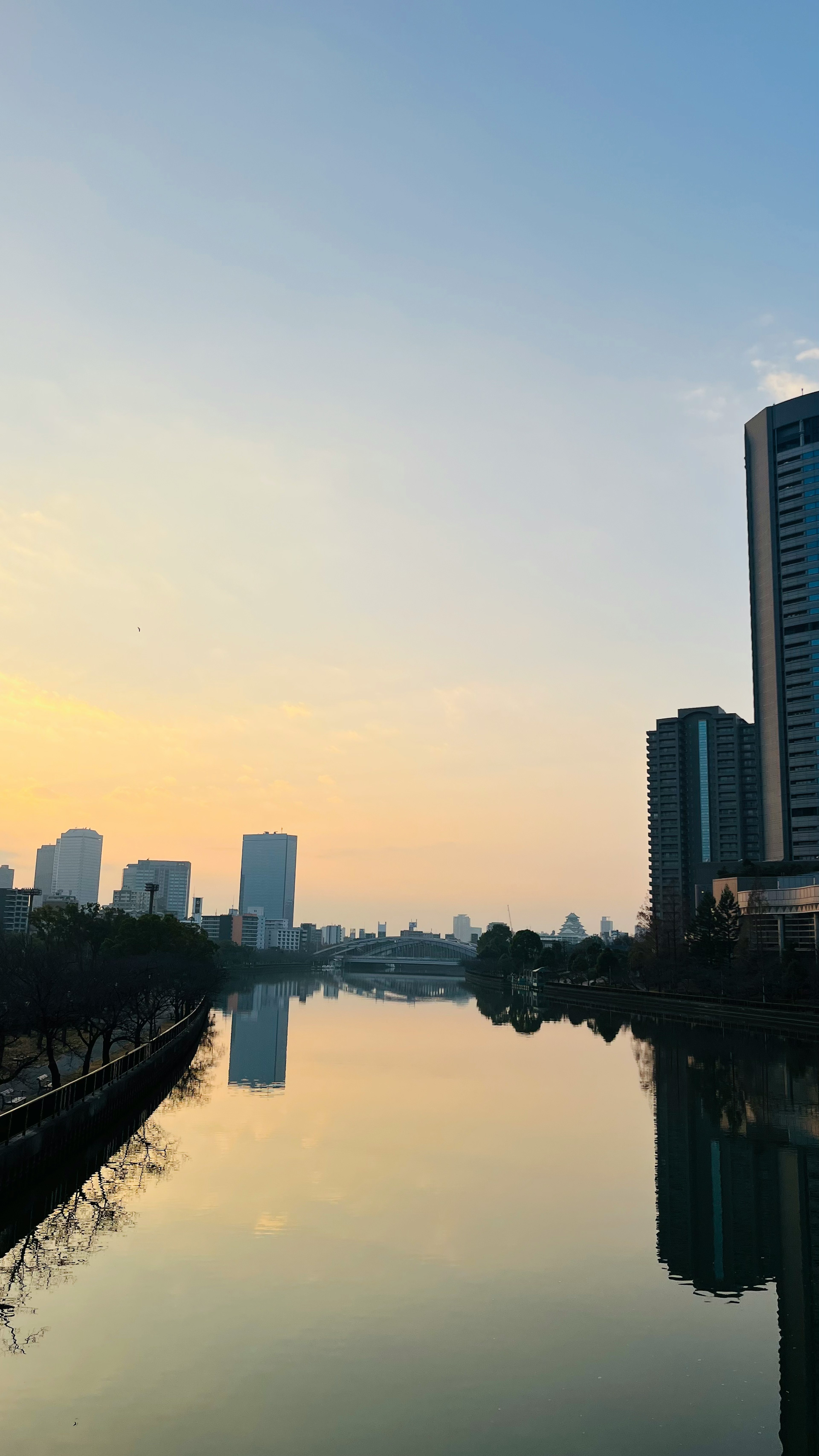 Reflet de la skyline urbaine sur une rivière au coucher du soleil