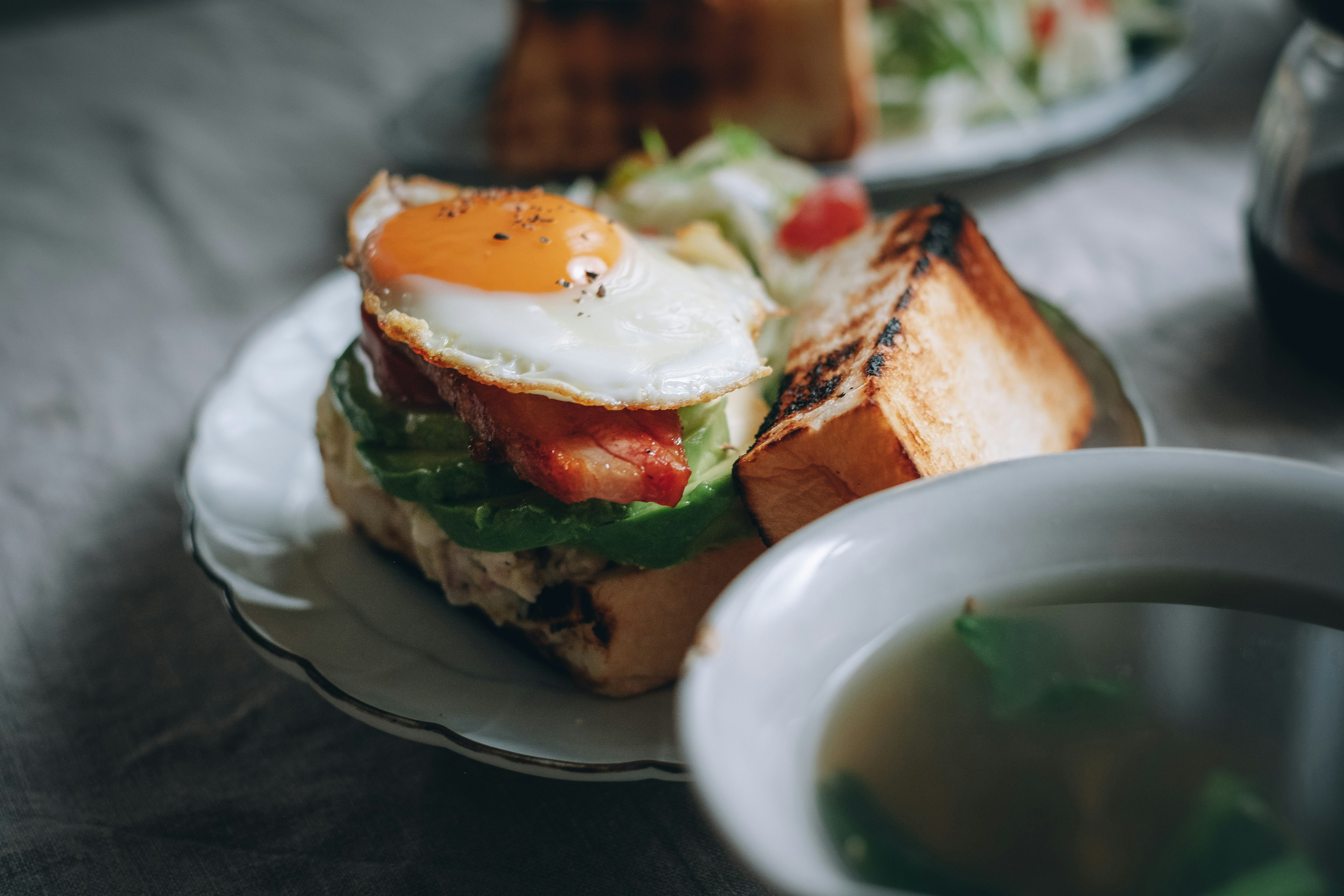 Sarapan lezat dengan telur goreng dan sayuran di atas roti panggang