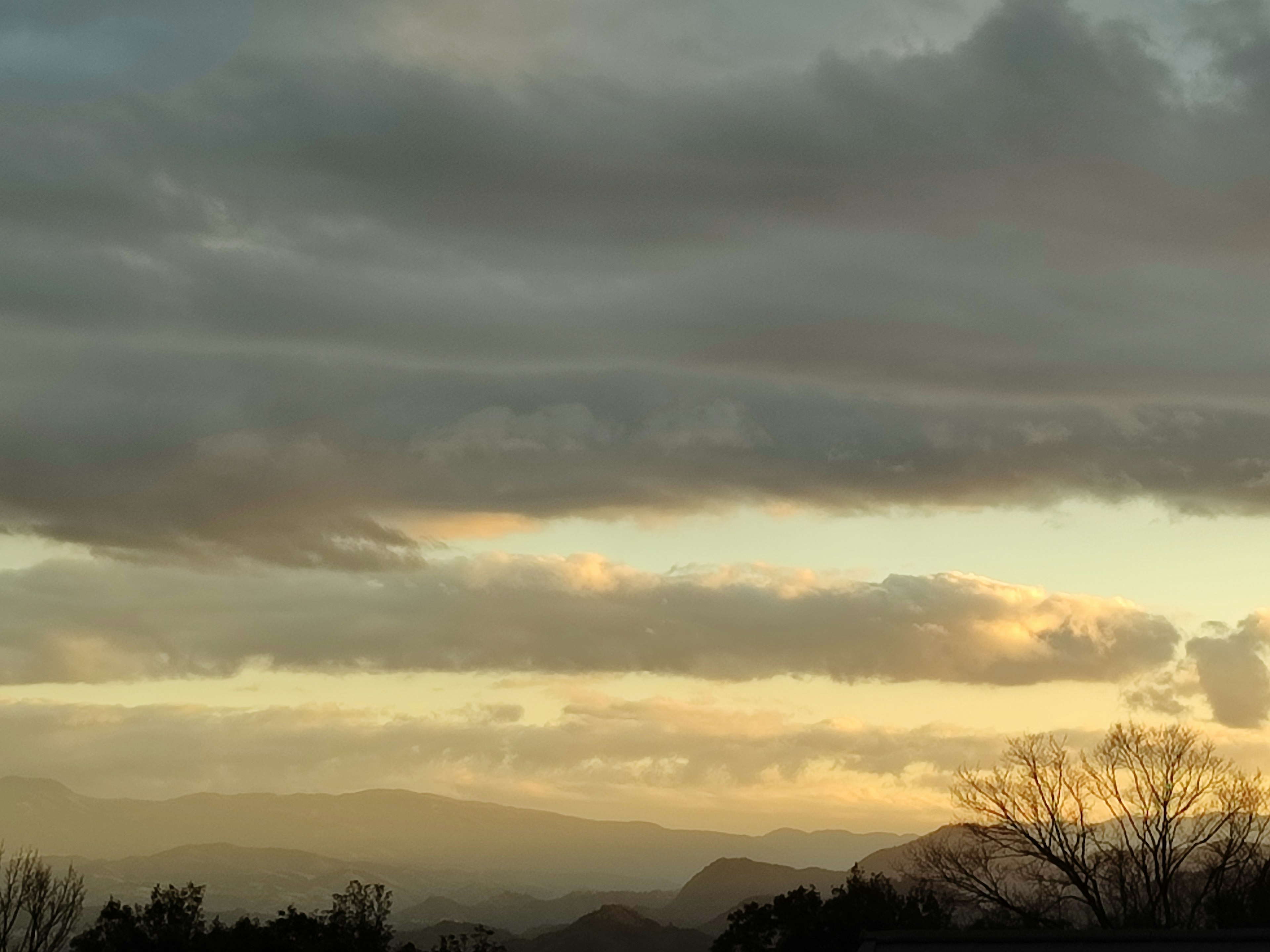 夕焼けの空と雲が広がる山の風景