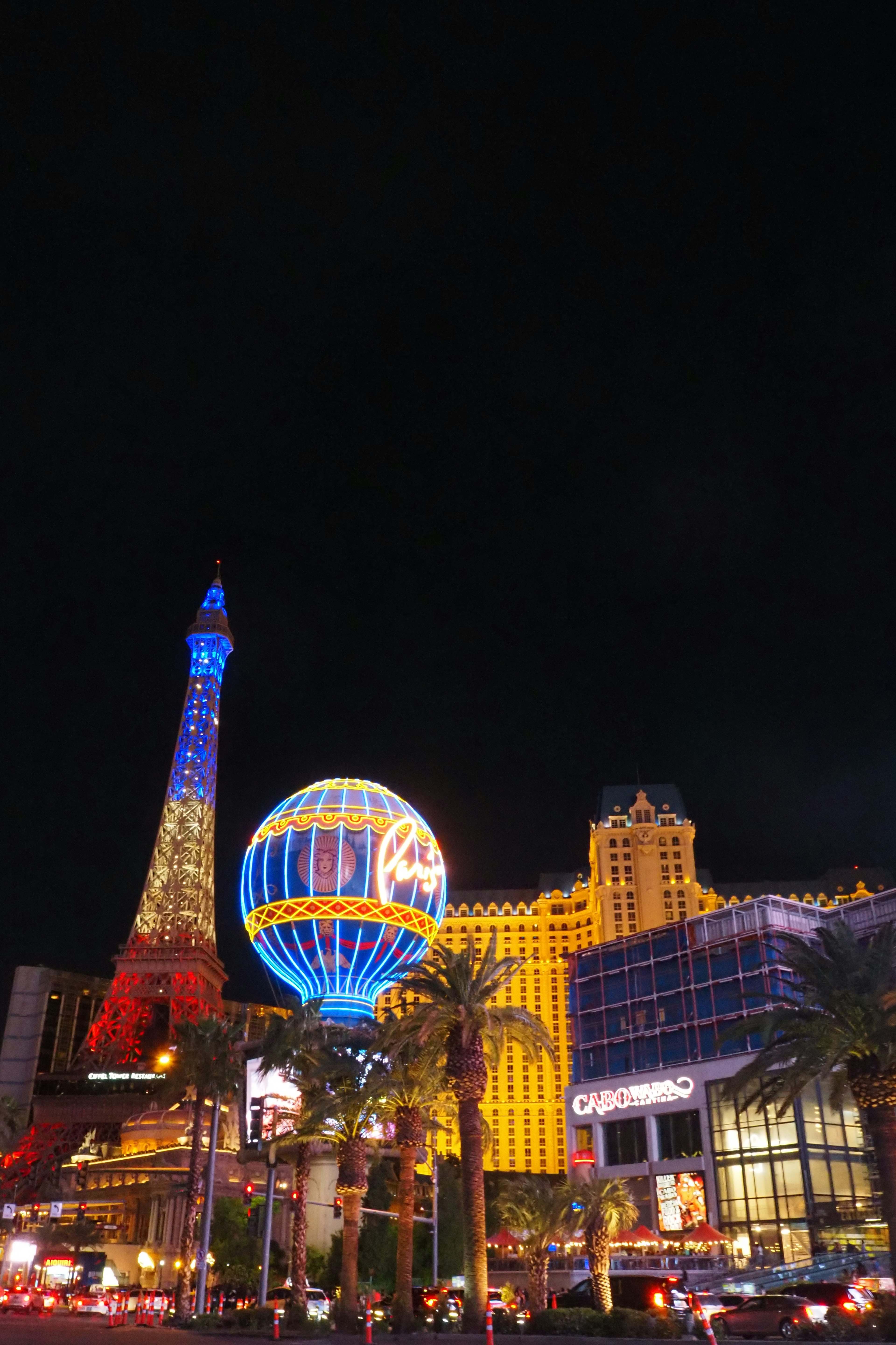 Vista notturna di Las Vegas con replica della Torre Eiffel e ruota panoramica illuminata