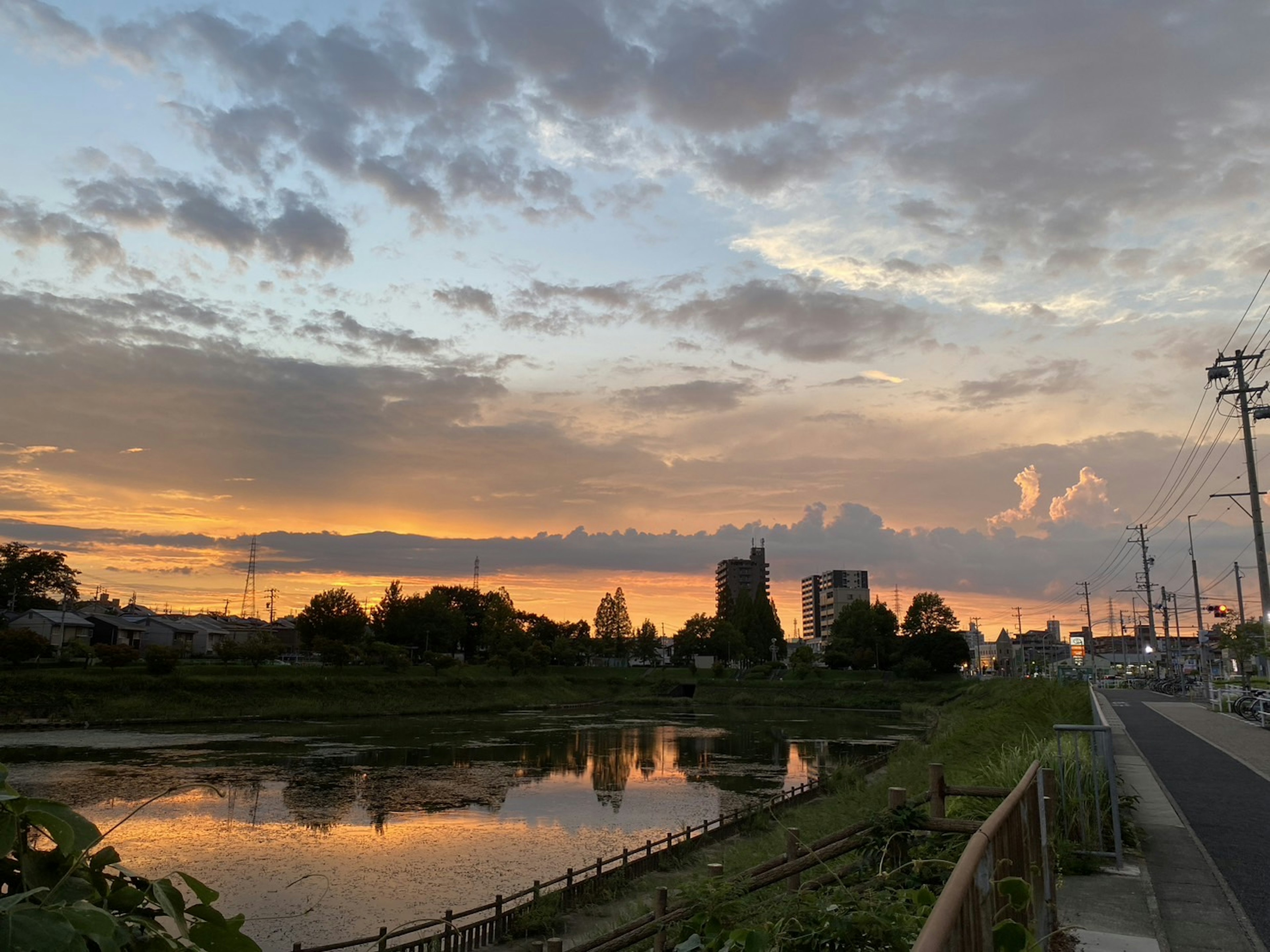 美麗的夕陽映照在河流上，周圍有建築物