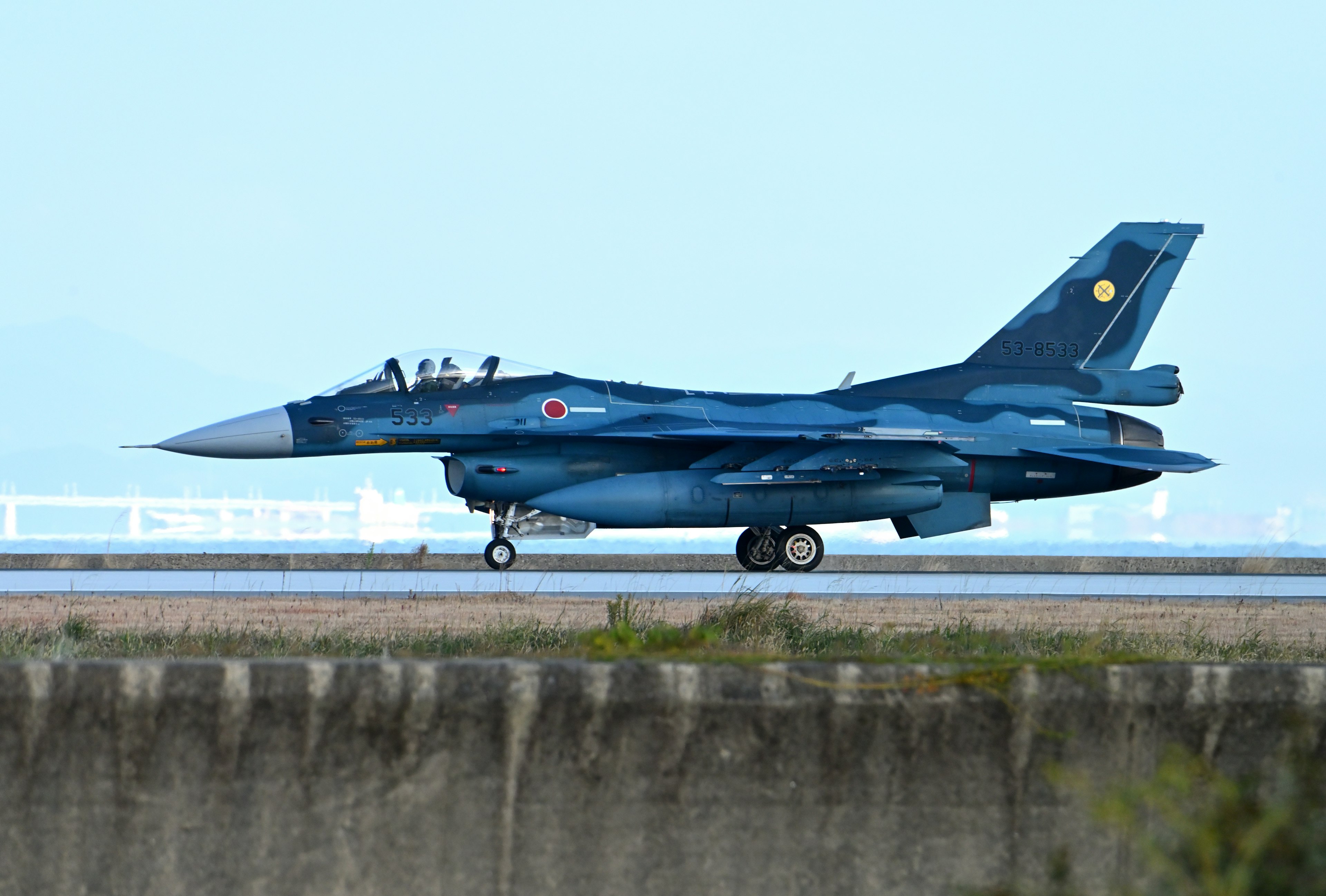 Blue F-2 fighter jet taxiing on runway