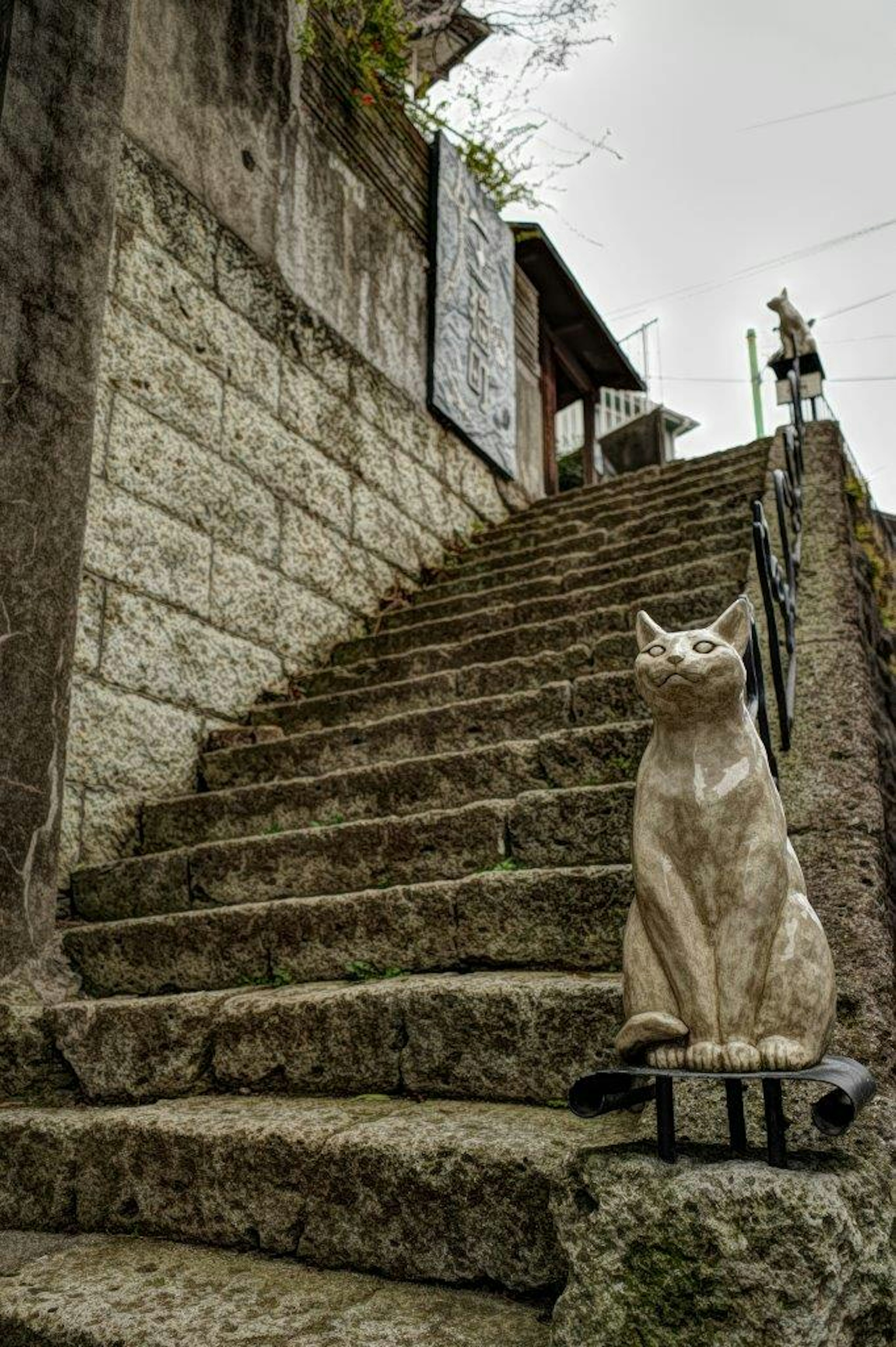 Cat sculpture sitting beside stone stairs