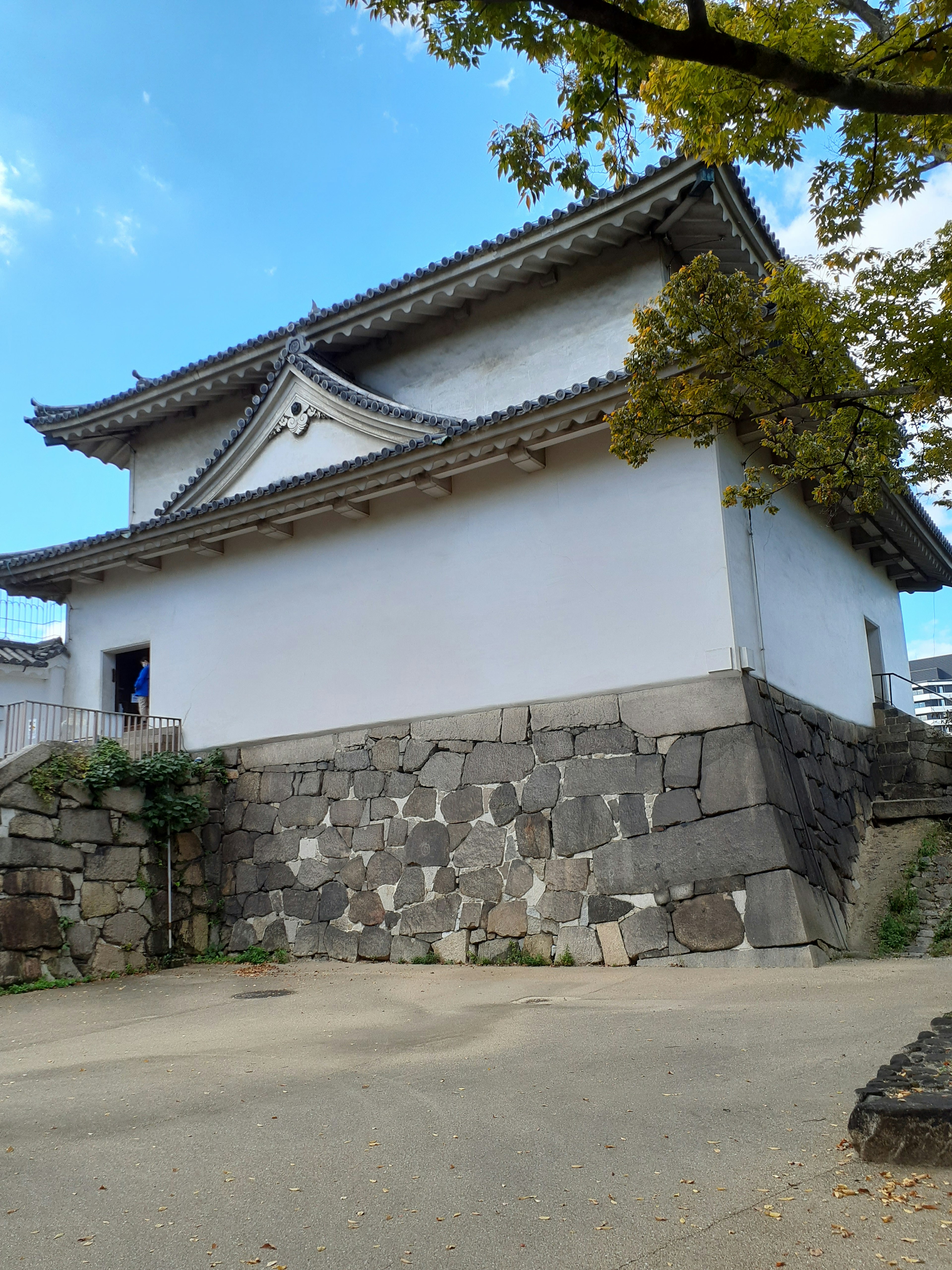 白い壁の城郭と石垣が見える風景