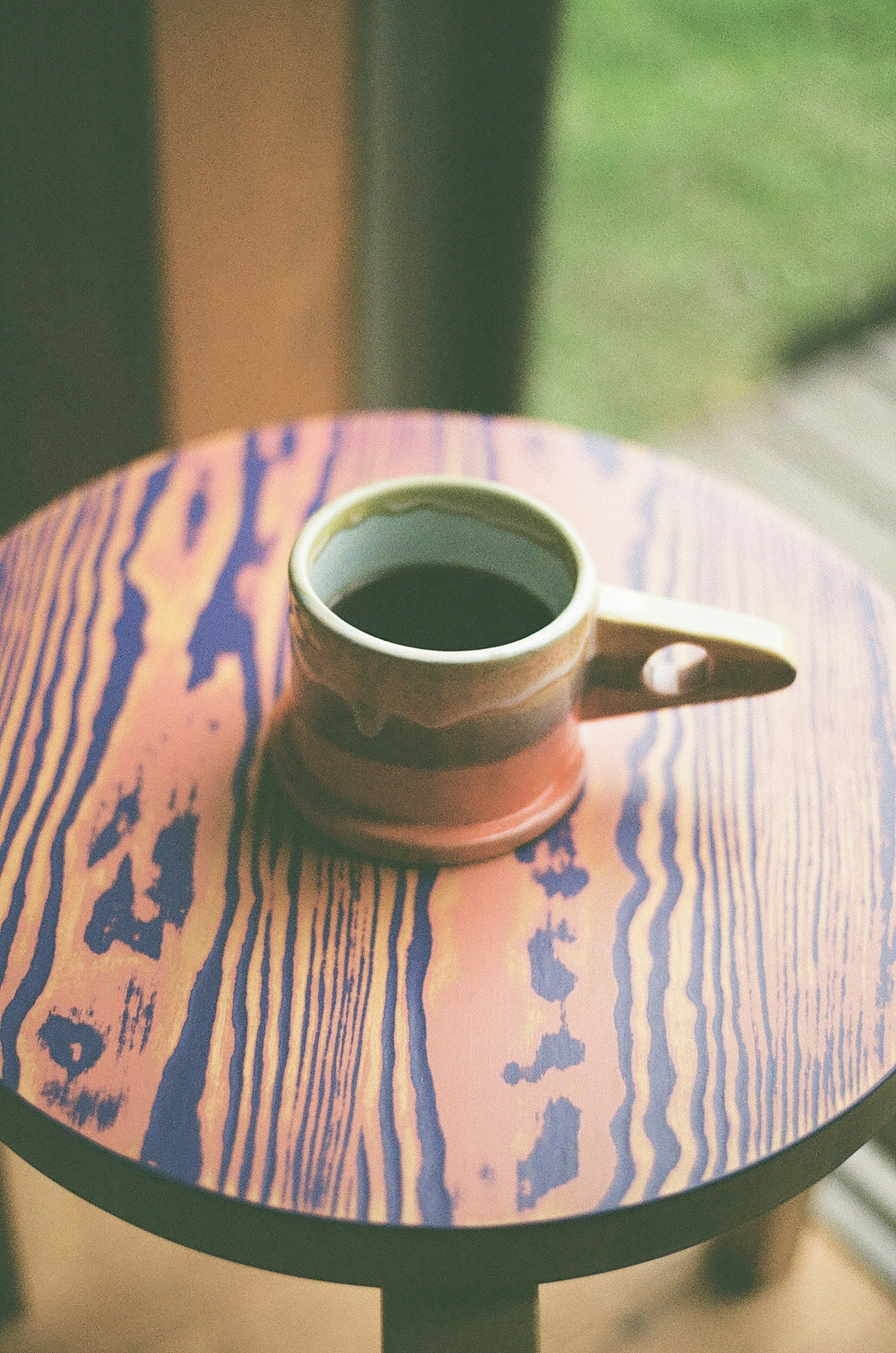 Kaffeetasse auf einem gemusterten Holztisch