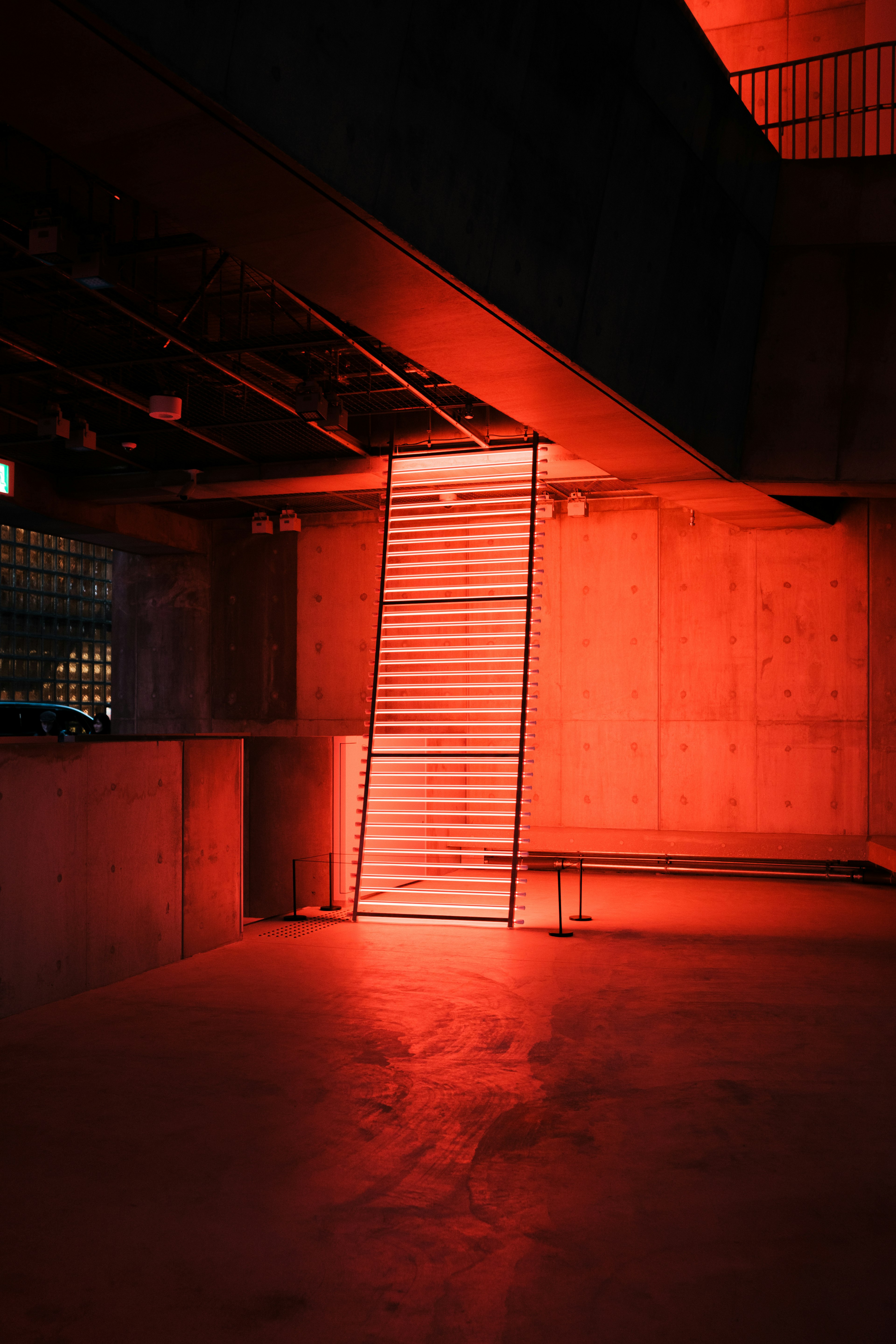 Pared de concreto y escalera iluminadas por luz roja